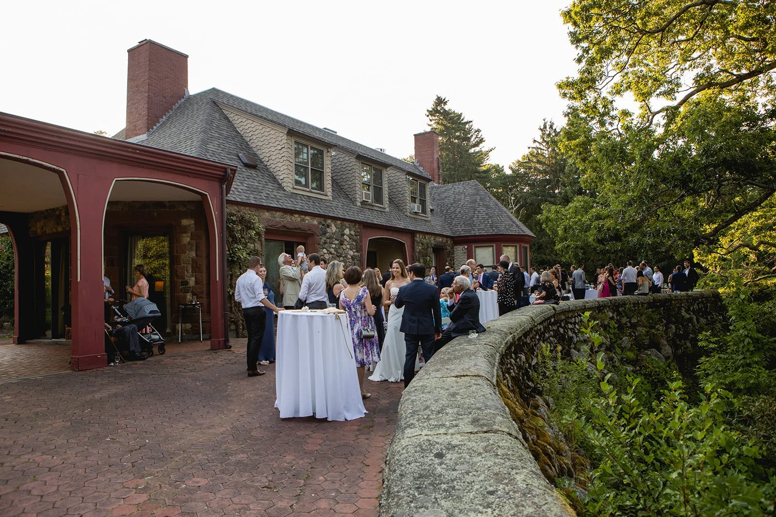 Guests gathered for cocktail hour outside estate building at Estate at Moraine Farm wedding in Beverly, MA
