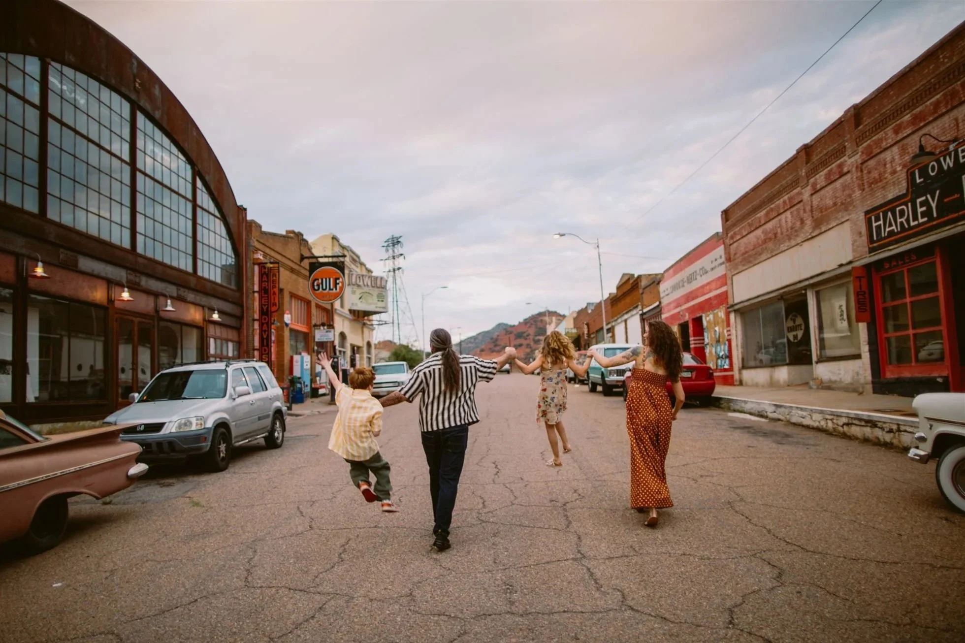 Family walking down a street in Lowell, Bisbee Arizona during cinematic lifestyle photography session