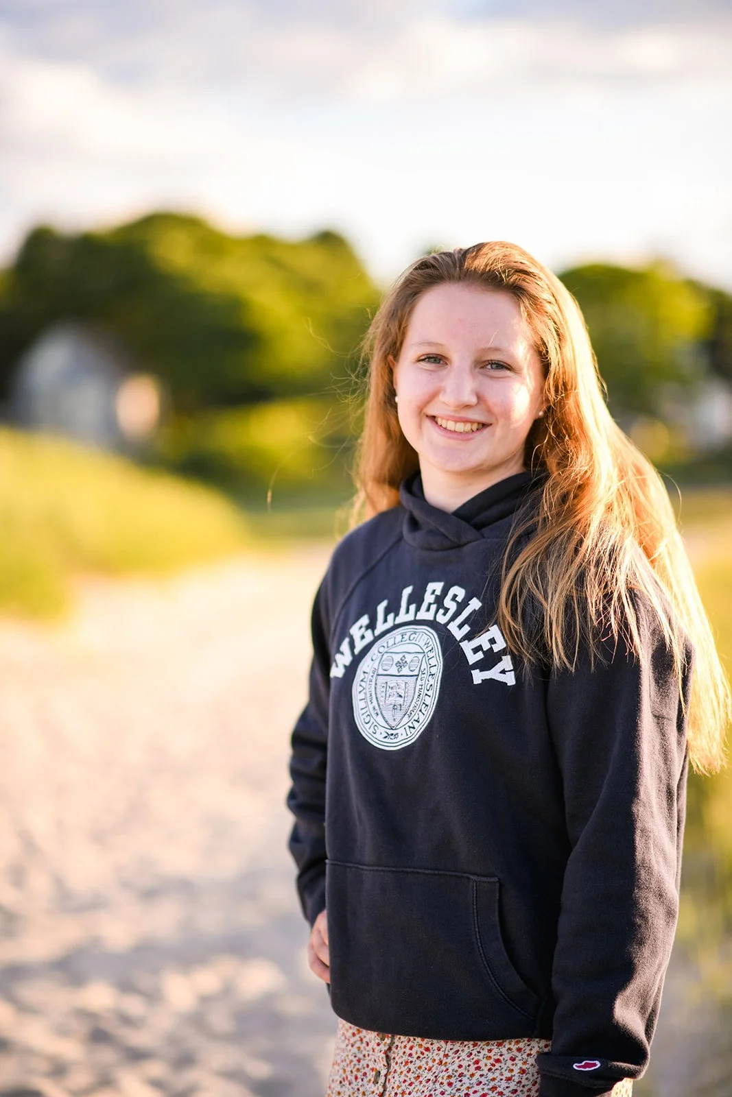 High school senior smiling in a casual outfit during an outdoor senior photo session in the Boston area.