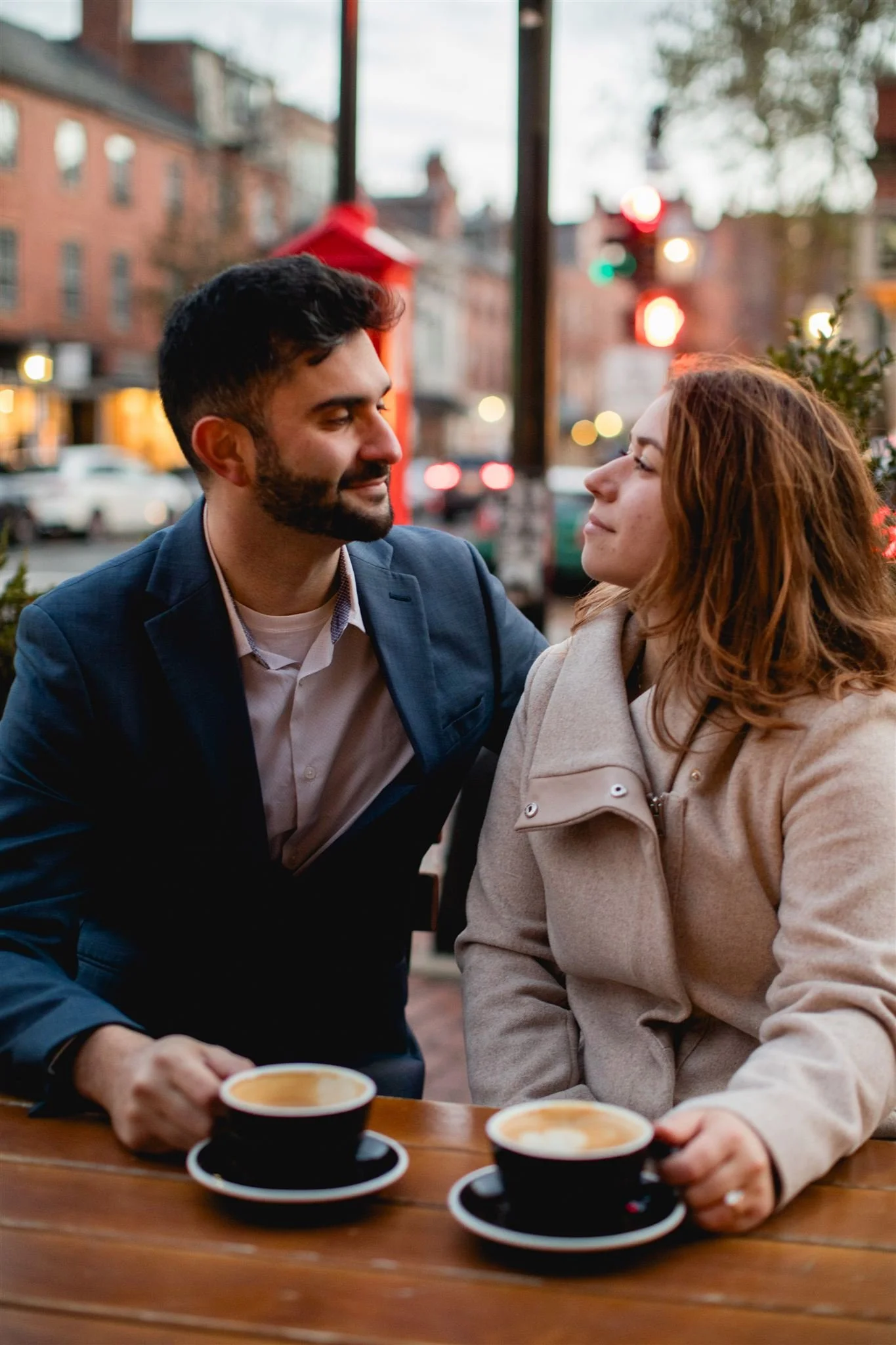 Couple enjoying coffee together at an outdoor café in Beacon Hill during a Boston engagement photo session.