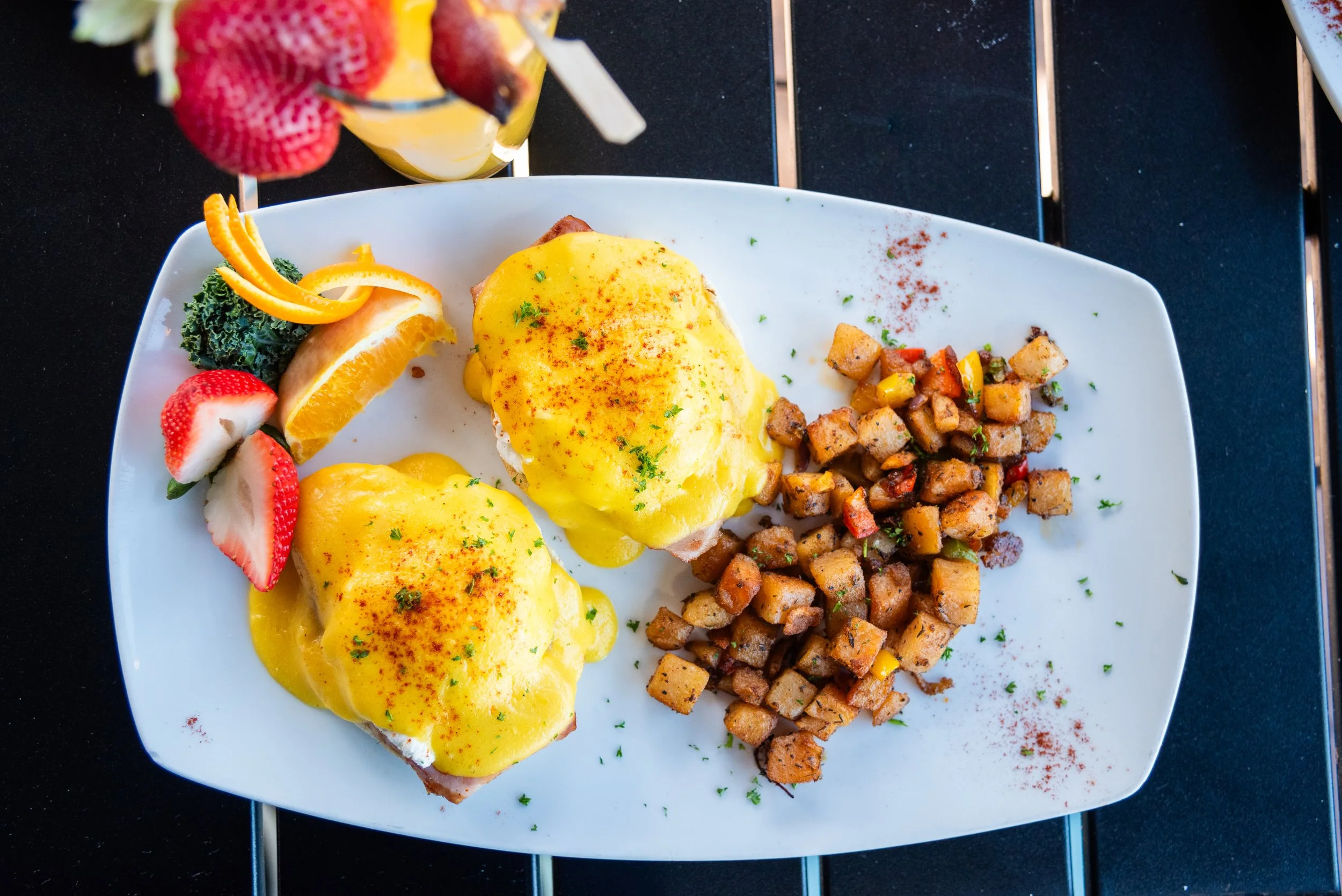 EGGS BENEDICT -  Two poached eggs atop Canadian bacon on English muffin halves.