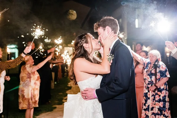 Couple kissing during a sparkler send-off