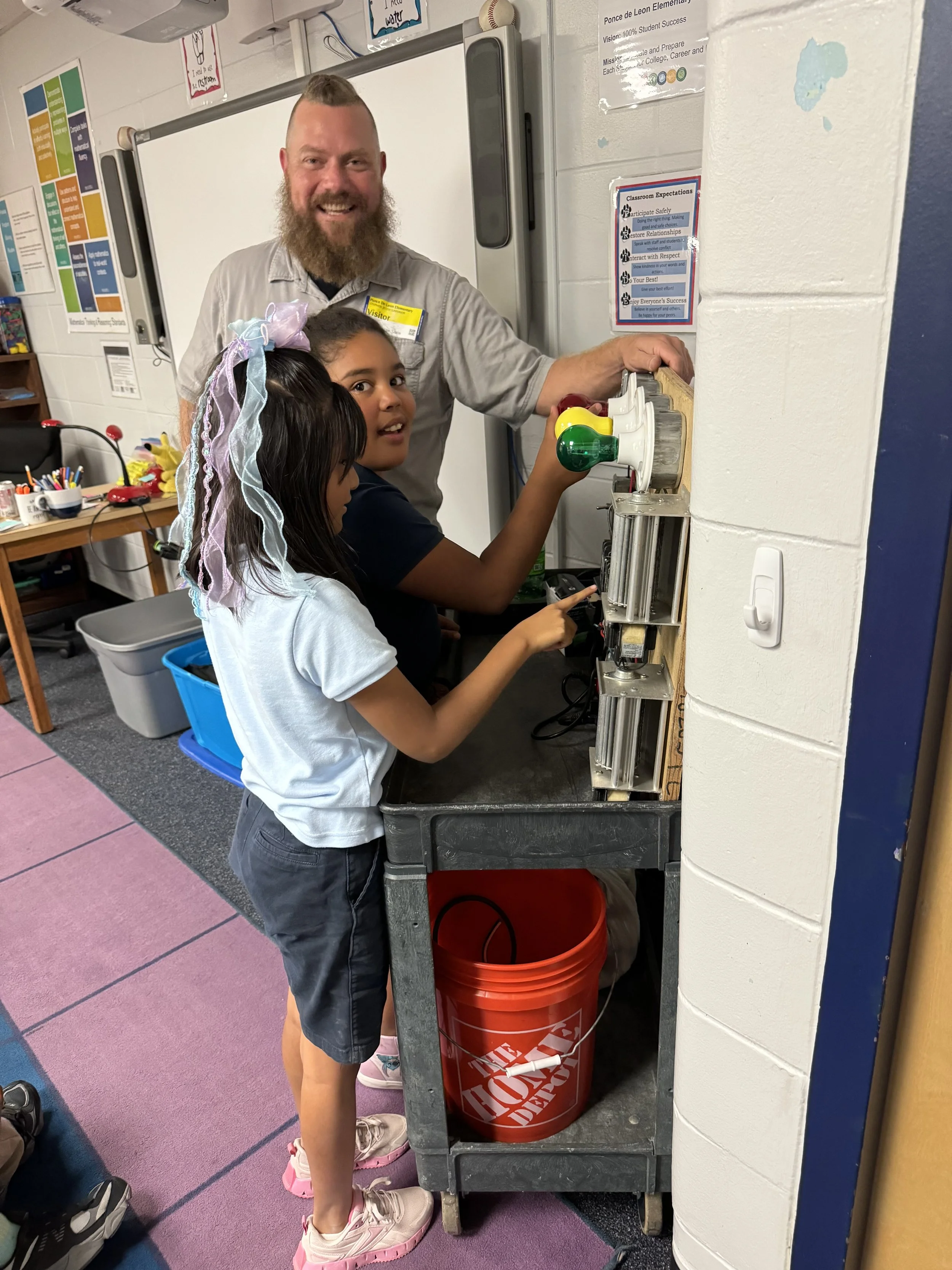 Stephen teaching kids at a school about lighting and electrical