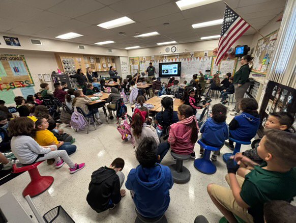 Stephen teaching kids at a school about lighting and electrical