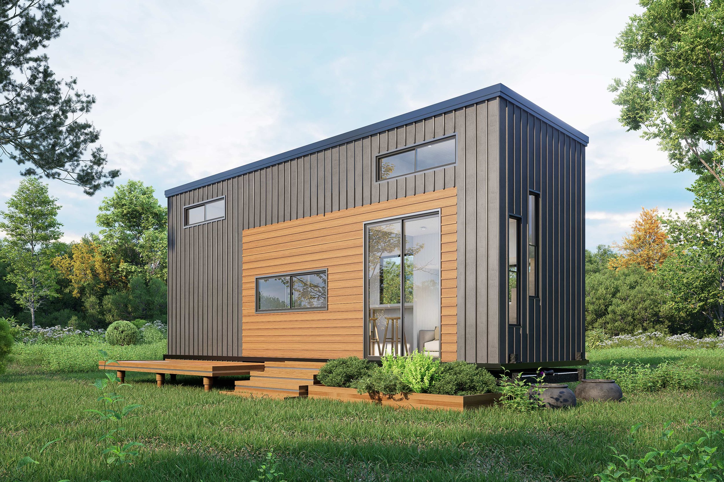 Modern two-story tiny house with black and natural wood exterior, large windows, surrounded by green grass and trees.
