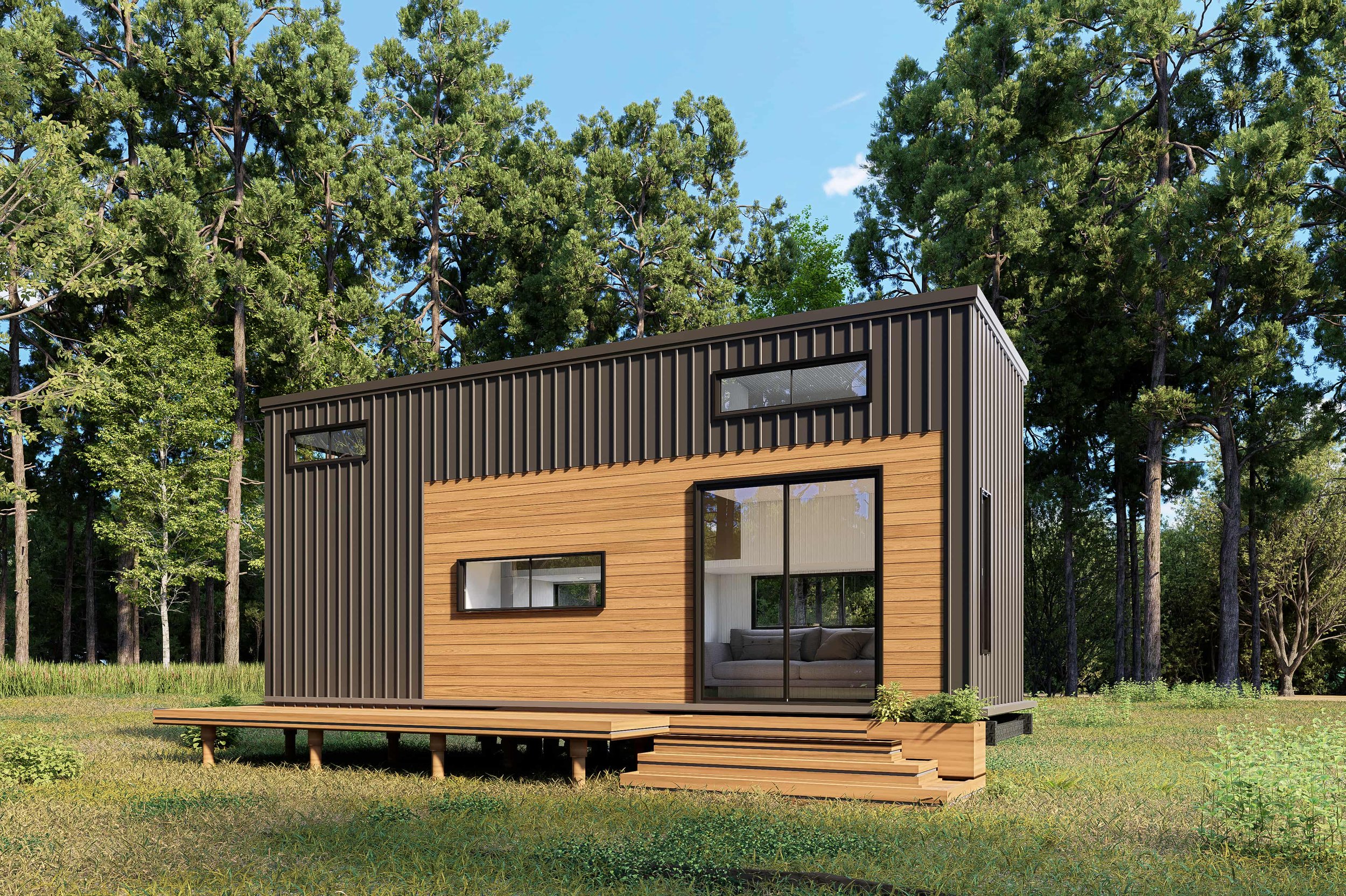 Modern tiny house with a wooden and black metal exterior, large glass sliding door, and deck stairs, situated in a forested area with green grass and tall trees.