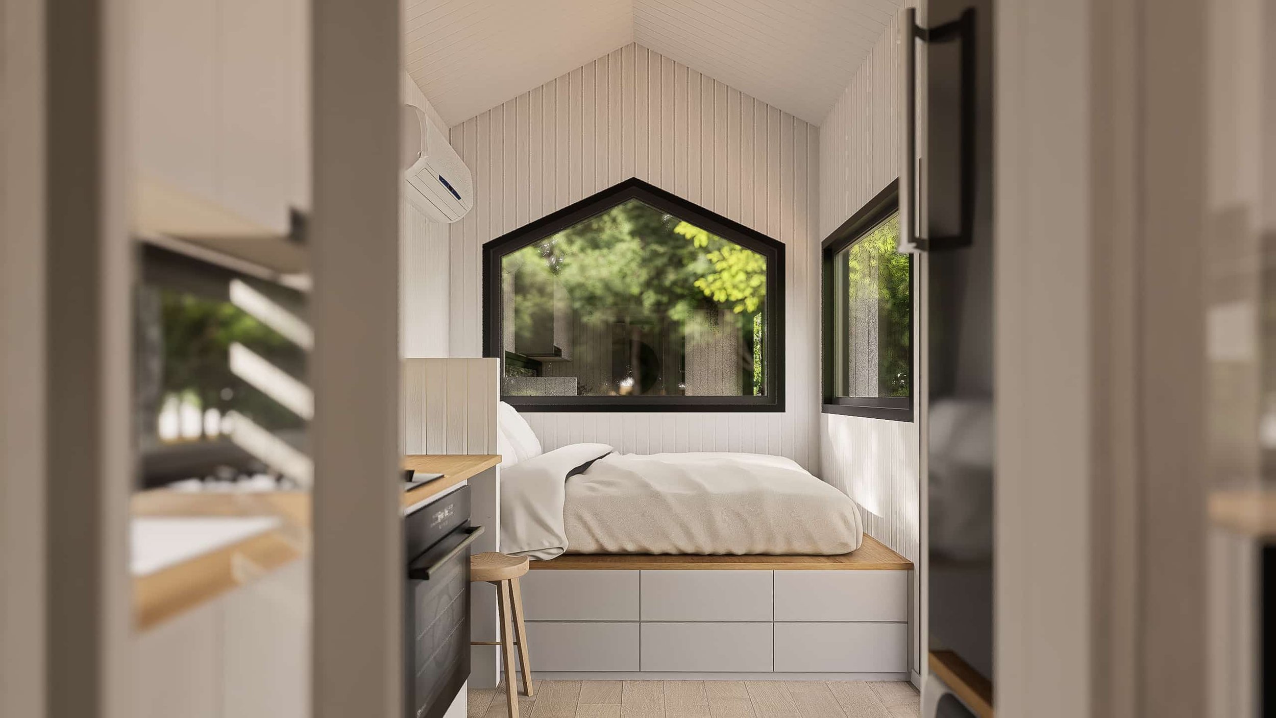 Small bedroom with white walls, wooden accents, built-in storage, a bed with white bedding, and large windows showing greenery outside.