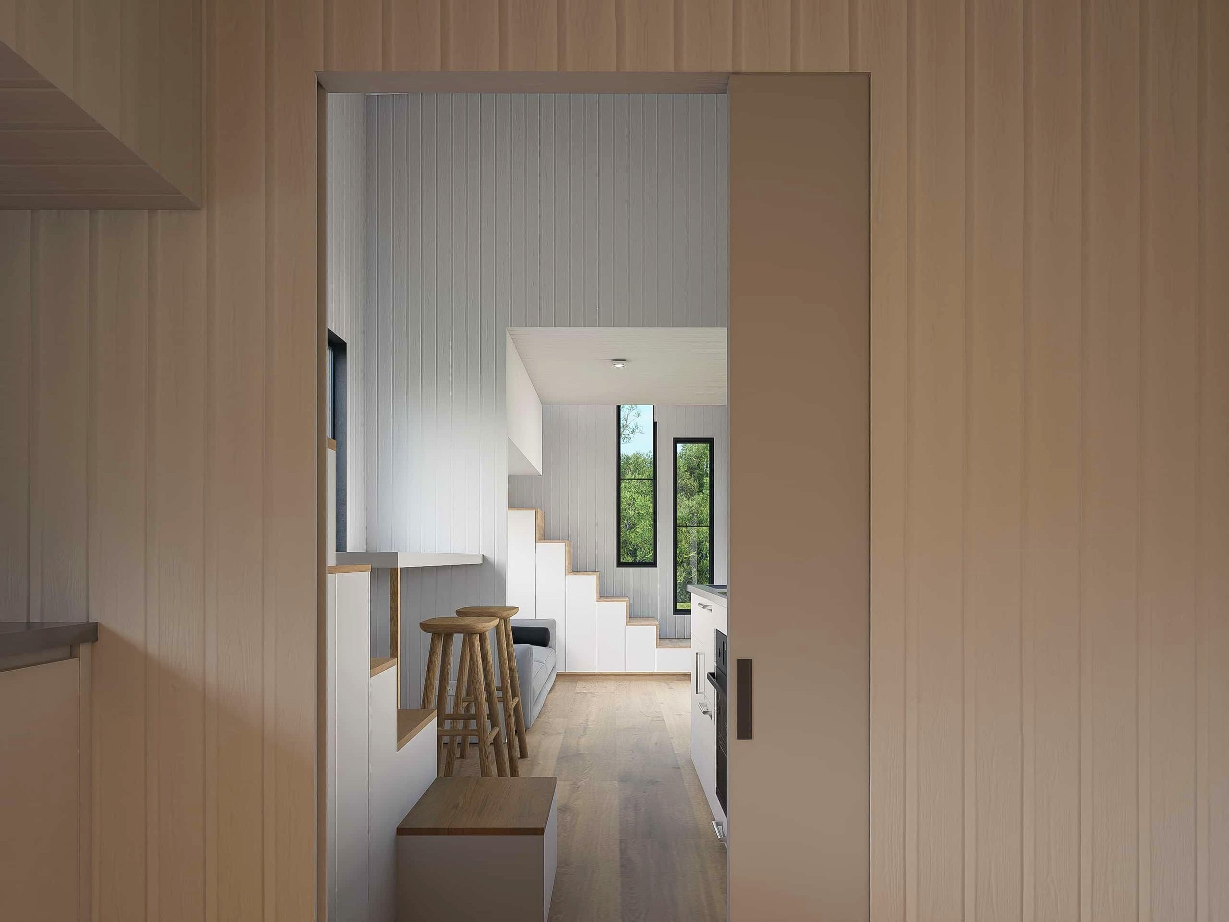 Inside view of a modern minimalistic room with light wood walls, a staircase, windows with trees outside, and bar stools in a cozy corner.