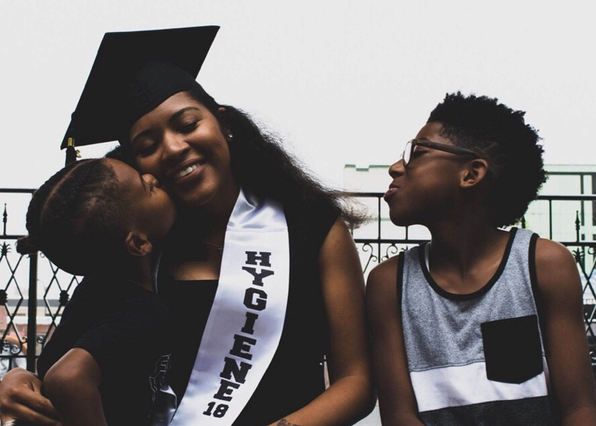 Image of a mother with her kids in a cap and gown after graduation