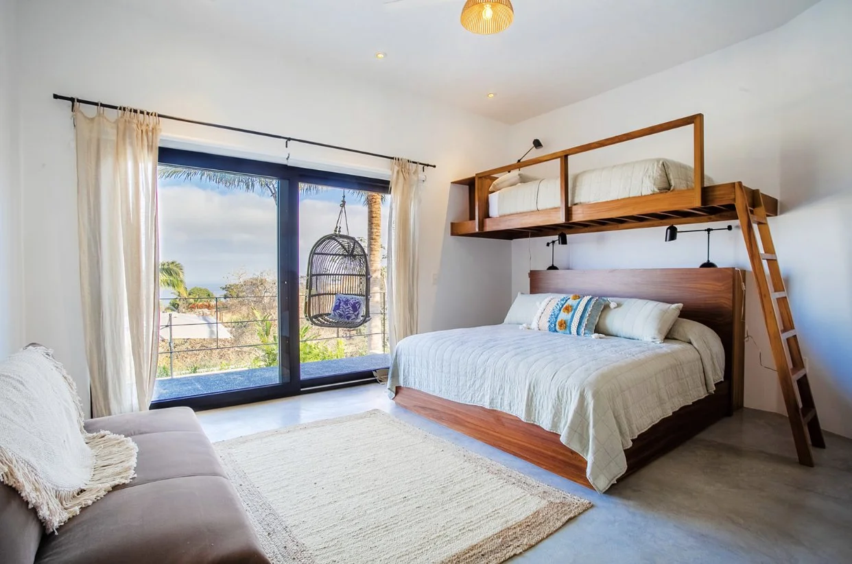 modern bedroom with large king bed with a loft bed above