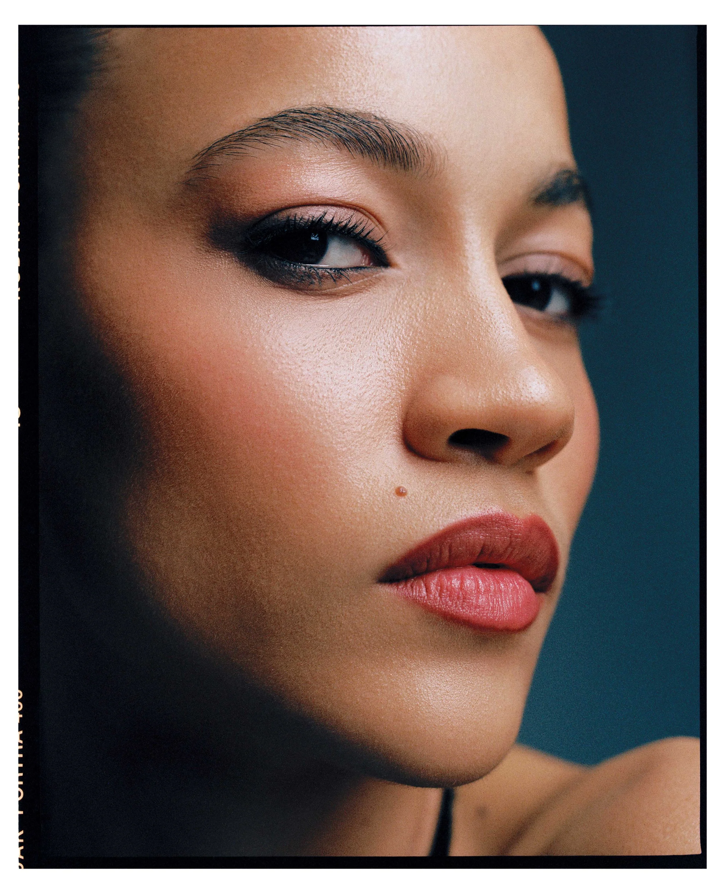 Close-up of a woman's face highlighting her eye makeup, well-groomed eyebrows, and smooth skin.
