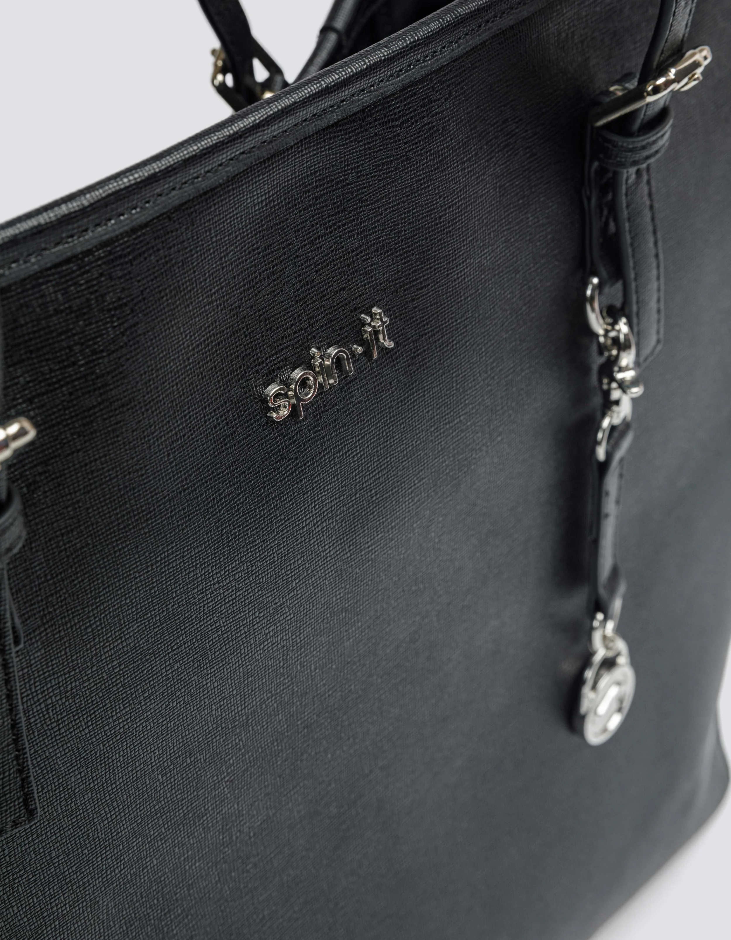 Close-up of a black textured leather handbag with silver hardware and the brand name 'spainit' in silver letters on the front.