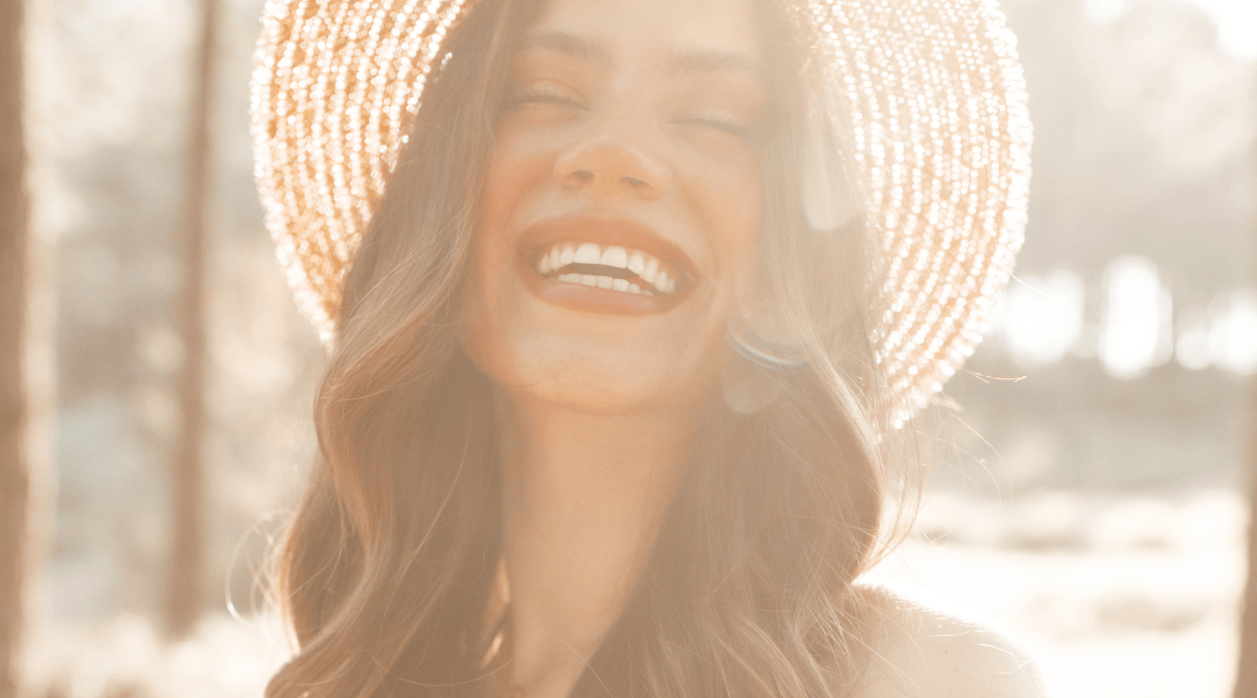 image of a woman smiling in the sun, representing self-worth and the importance of using affirmations to start your day
