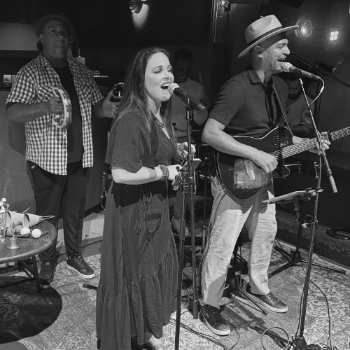 Foto do Alle e da Carol cantando.