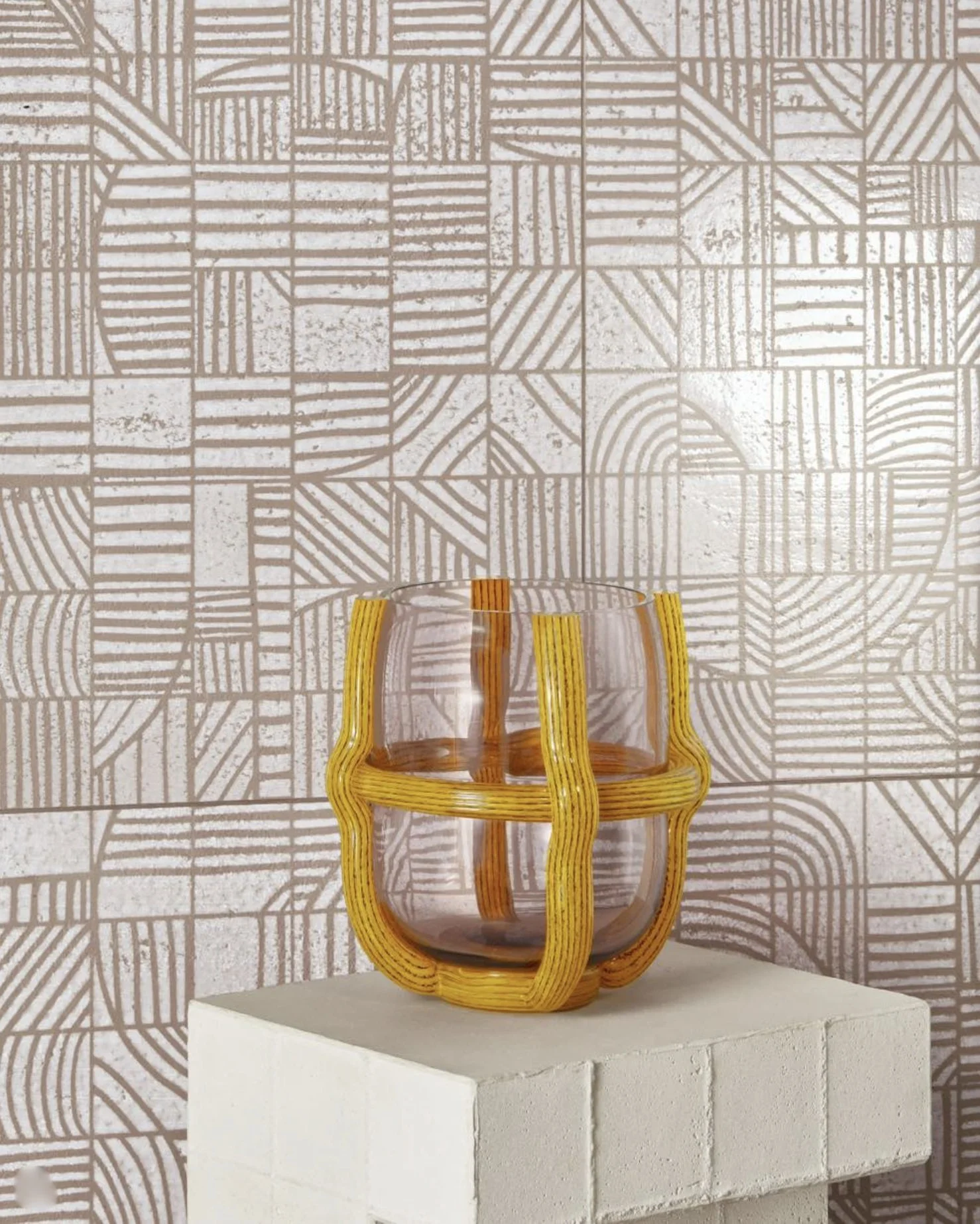 A decorative woven vase on a textured surface with geometric patterned wallpaper in the background.