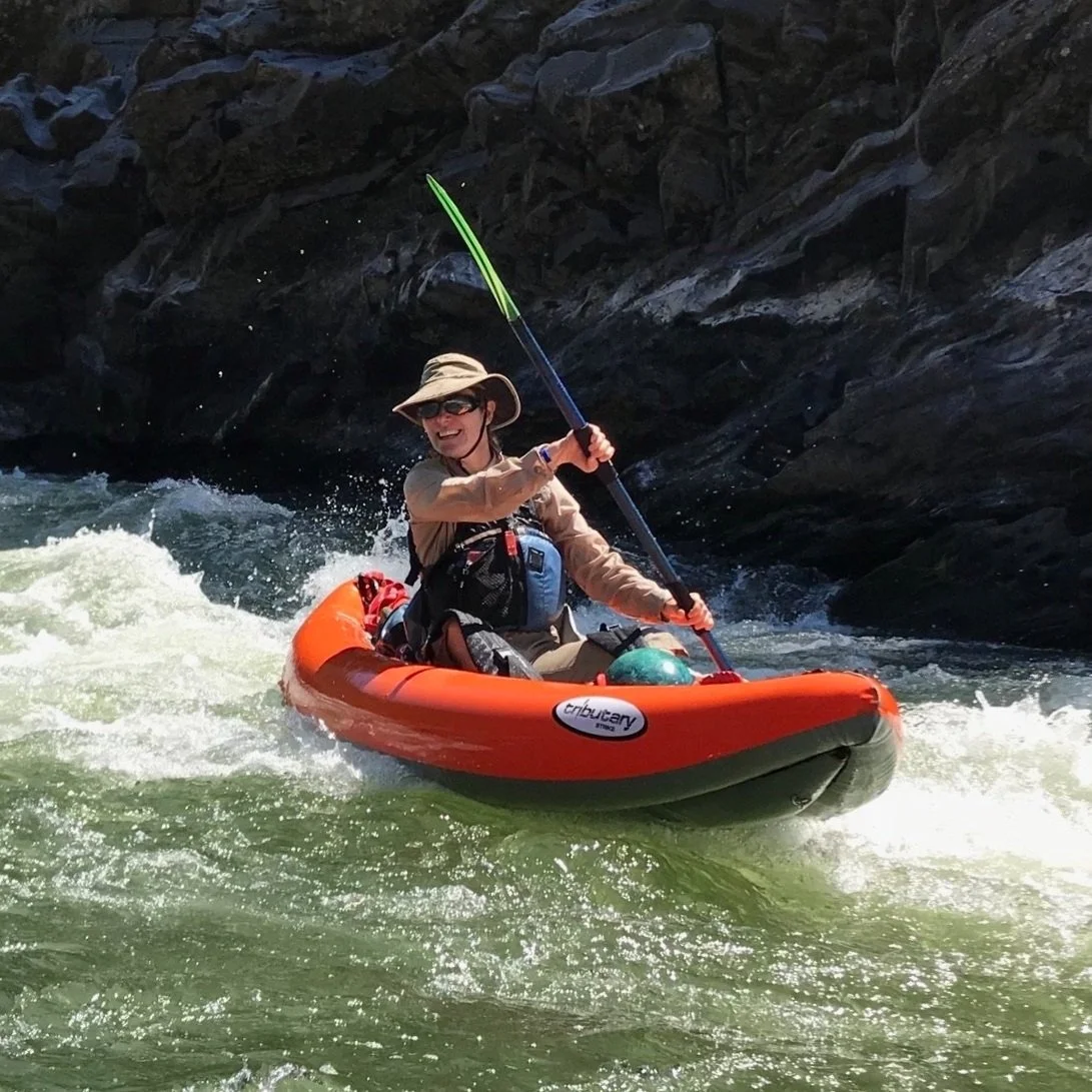 Person kayaking through whitewater rapids, representing resilience and navigating challenges