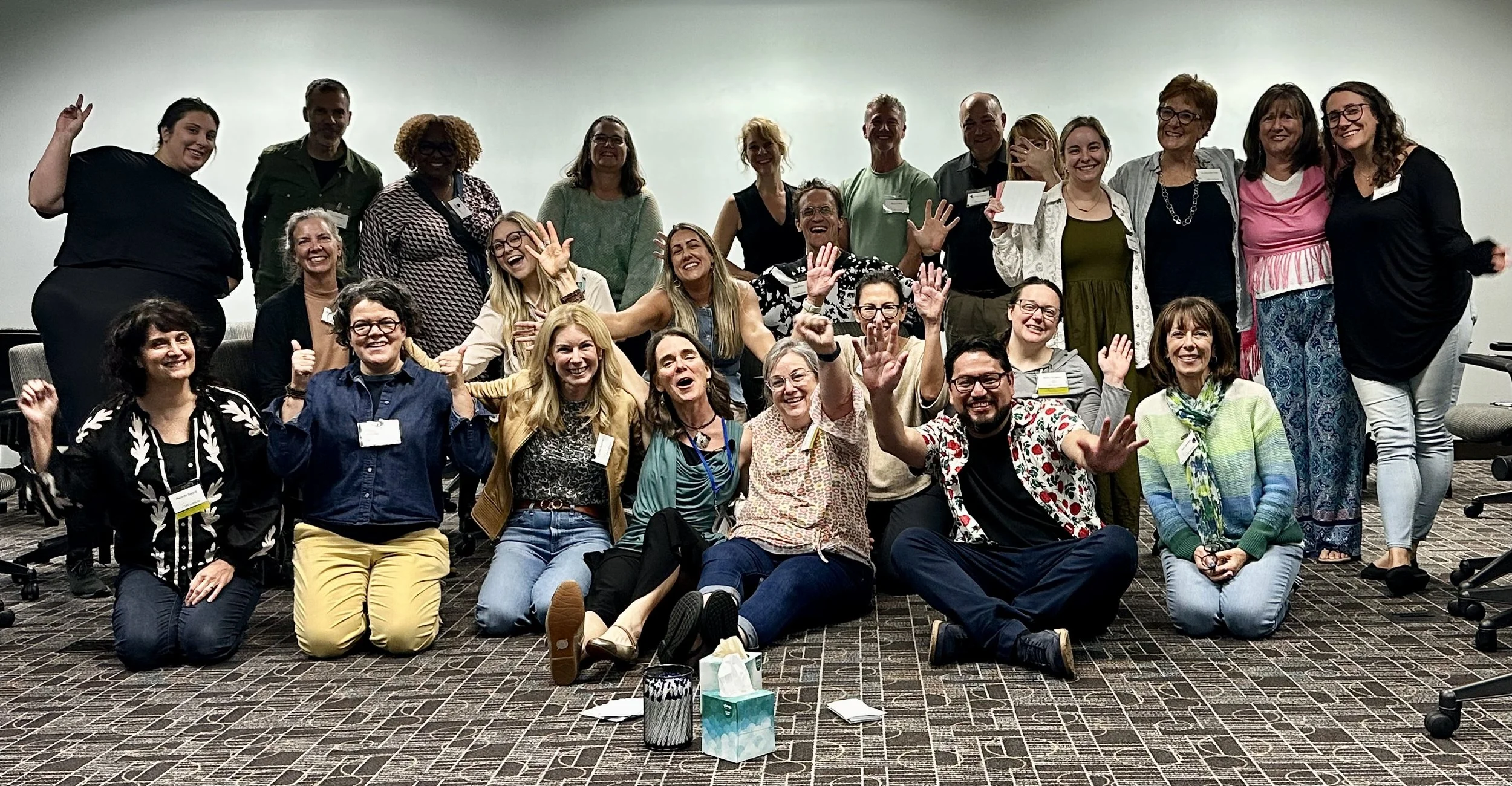 Group of people smiling and posing together at a workshop or event
