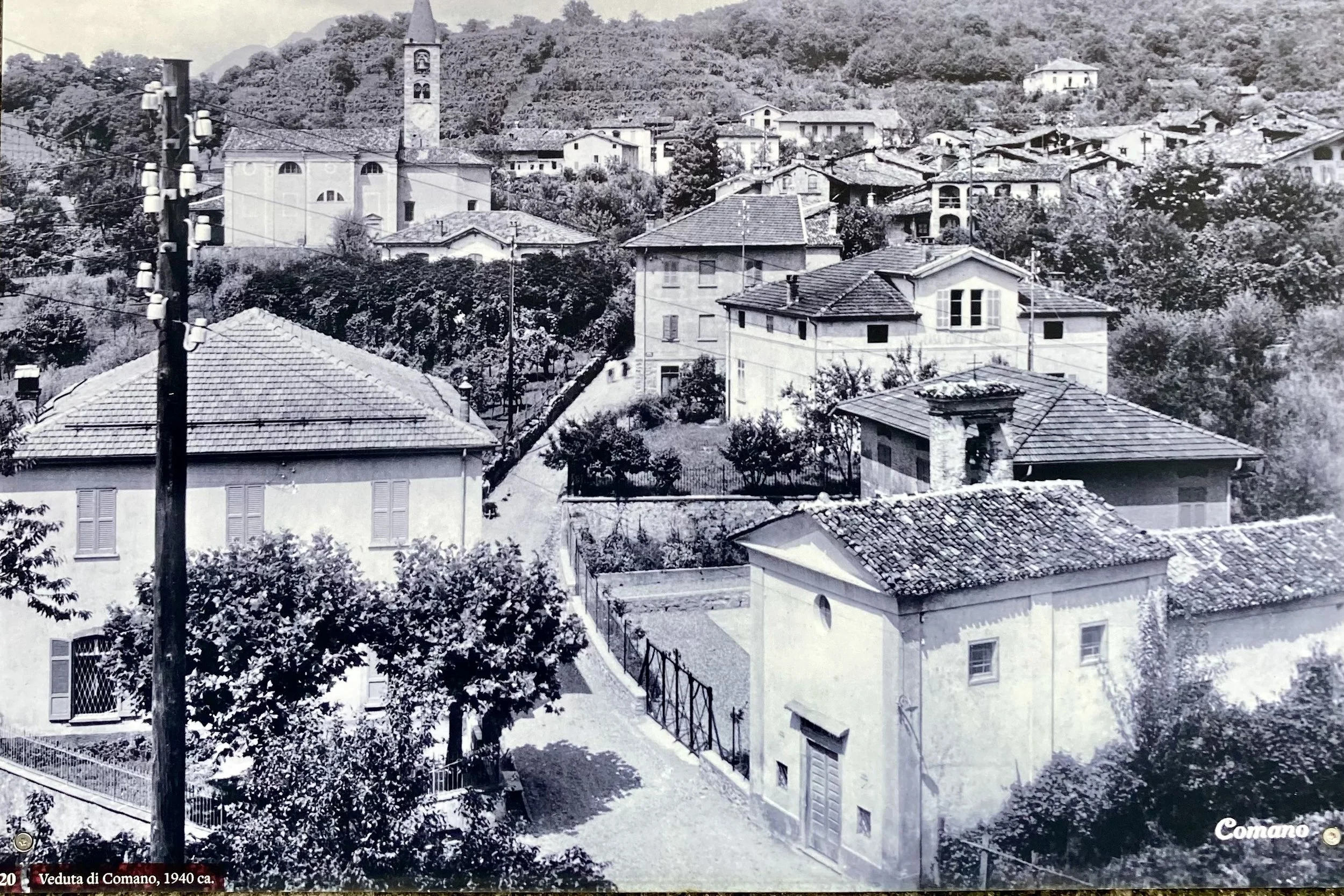 One of the old pictures posted throughout Comano.  The city administrative building and the Oratory buildings are found in the forefront of this picture.