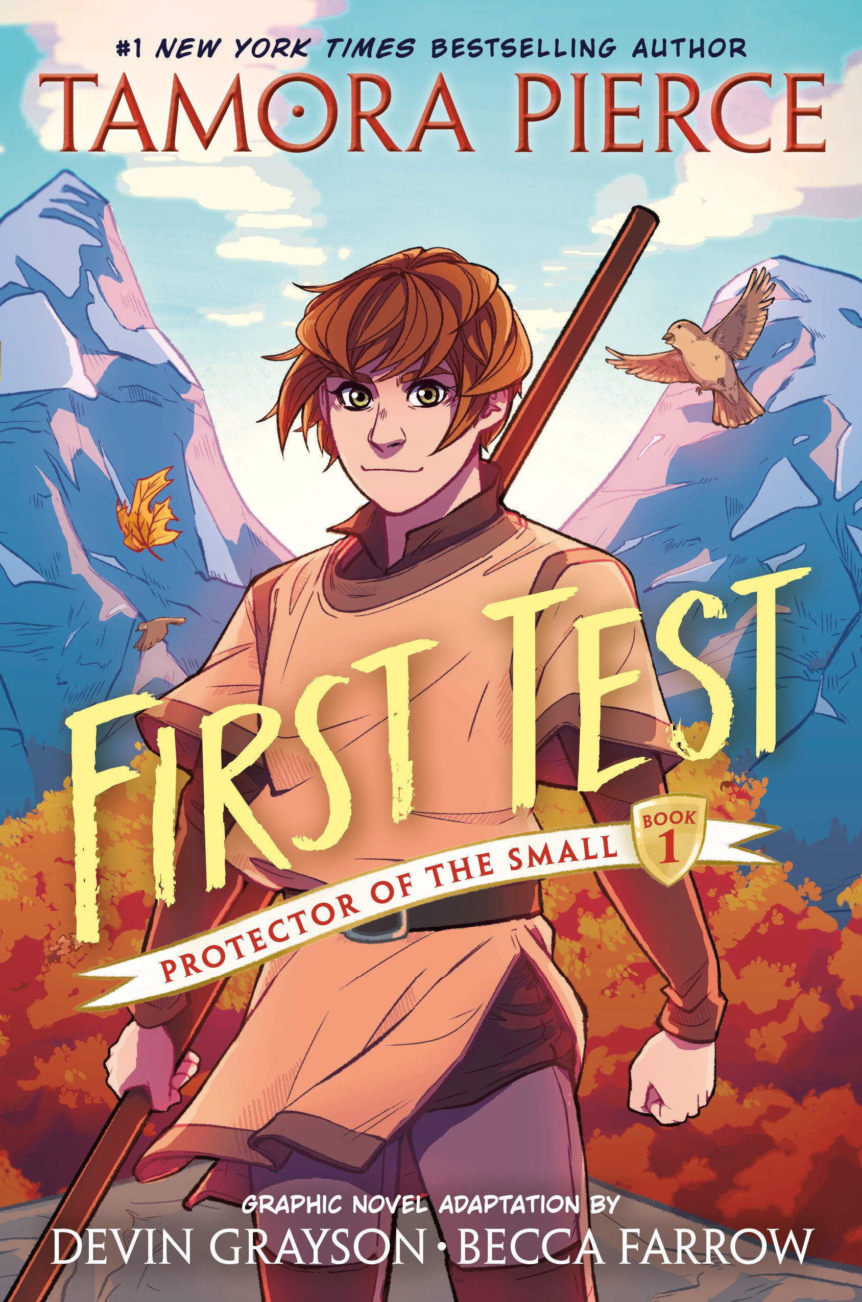 Cover of a graphic novel titled "First Test: Protector of the Small, Book 1" by Tamora Pierce. The cover features a young male character with short brown hair holding a staff, set against a backdrop of mountains and autumn foliage, with a flying bird