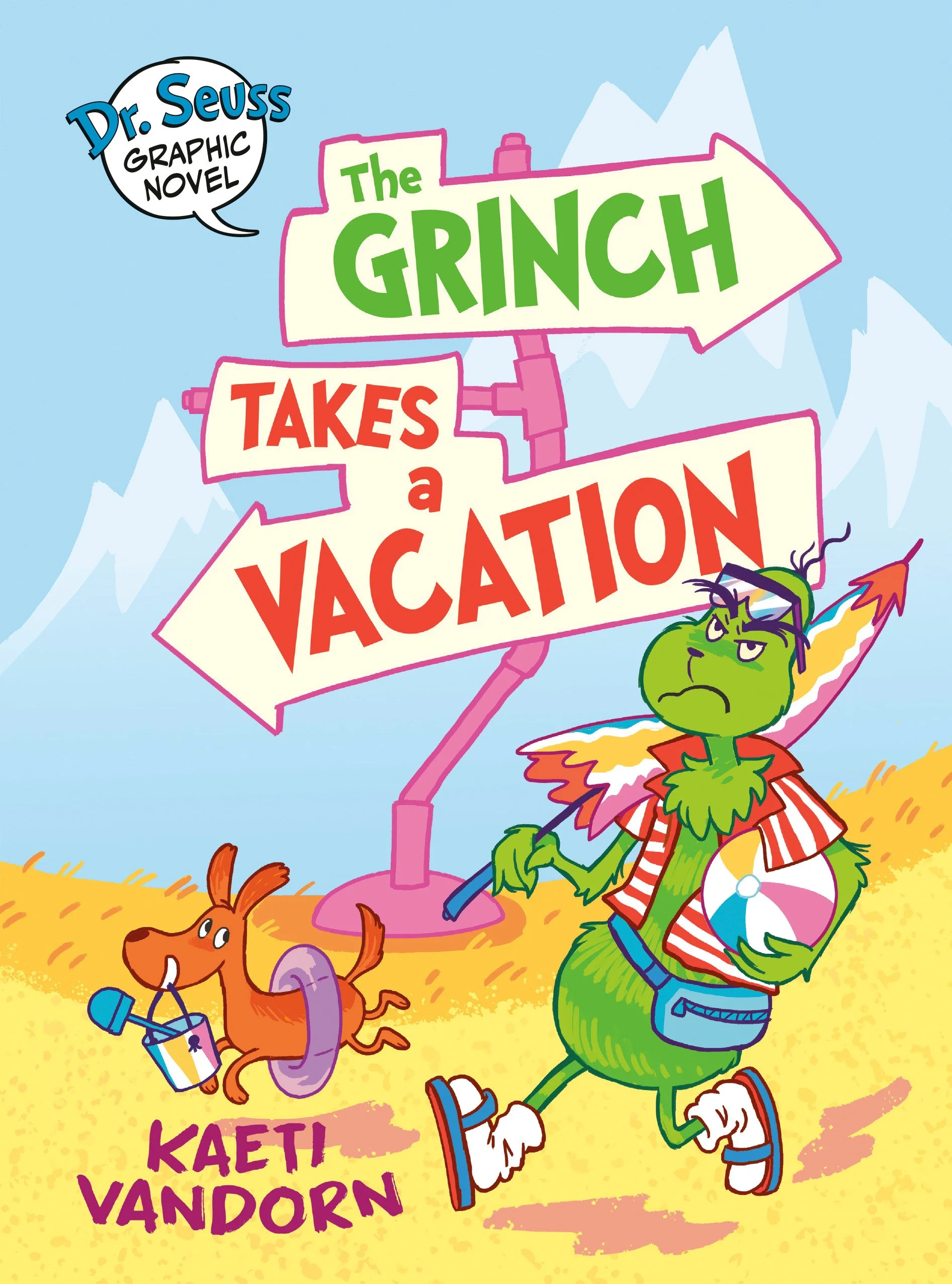 Cover of the graphic novel 'The Grinch Takes a Vacation' by Kaeti Vandorn, featuring the Grinch walking on the beach with a beach ball and wearing casual clothes, with a dog carrying a bucket and shovel. The background shows mountains and a signpost 