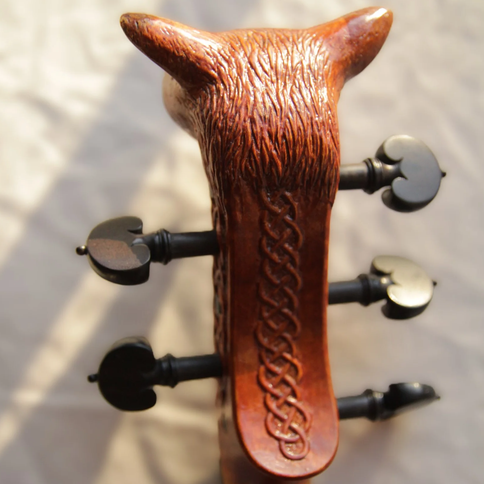 back of carved head scroll with celtic knot carving

