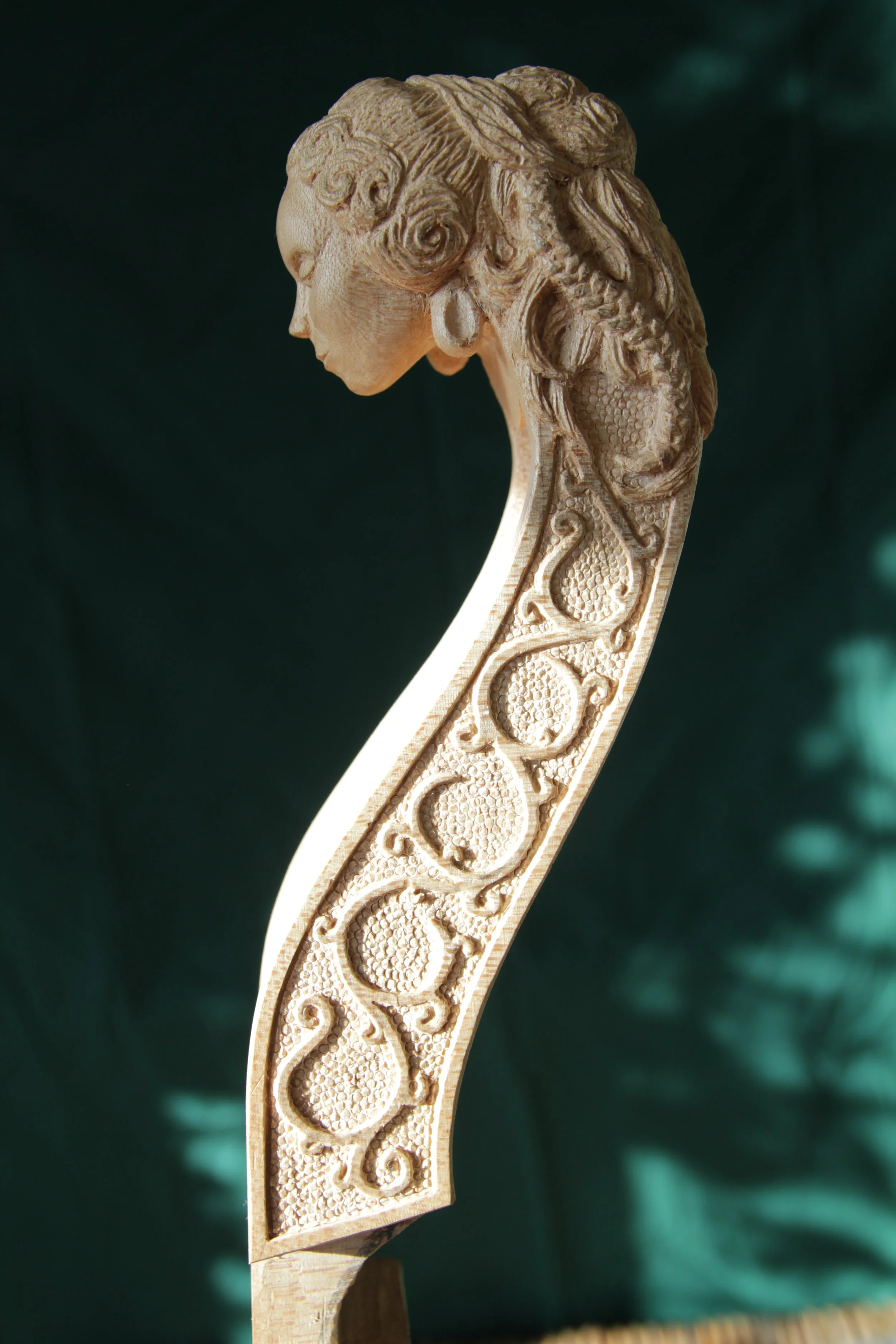 carved head of a woman with intricate relief carvings