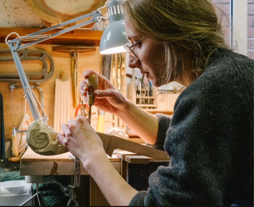 Alina Ehret working on a decorative carving in her workshop
