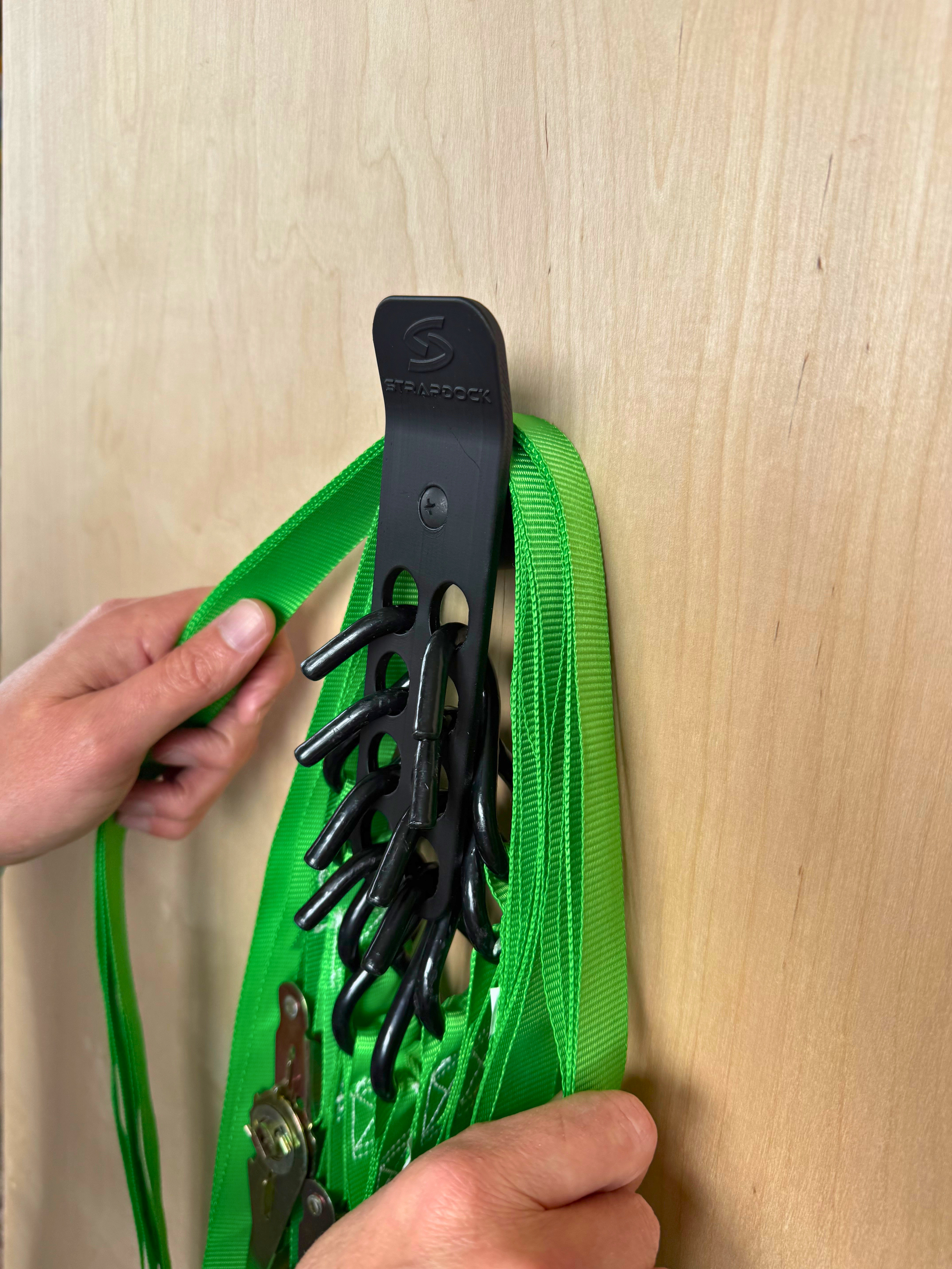Green ratchet strap tails being placed over StrapKeeper on StrapDock