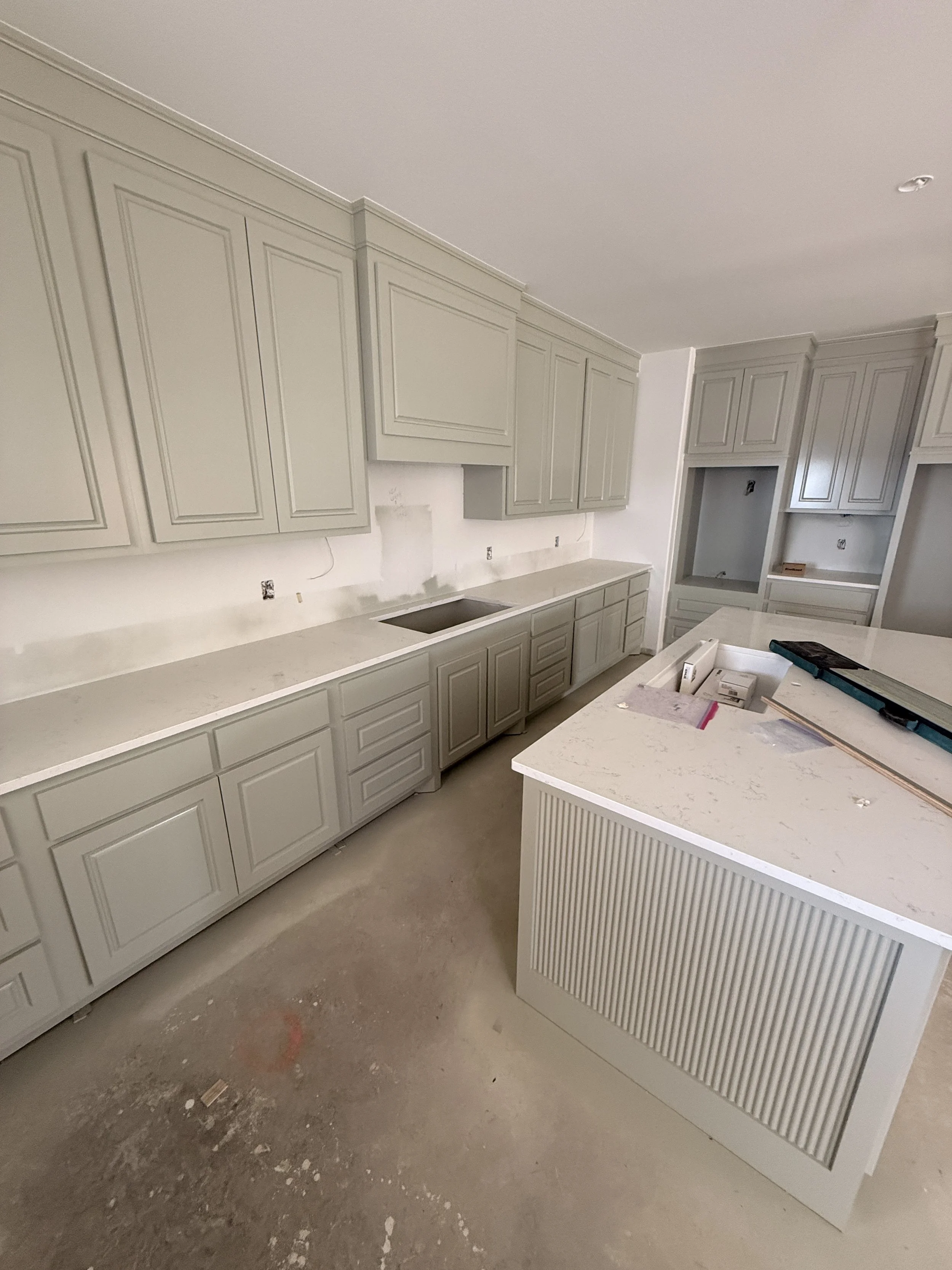 Kitchen cabinets under construction with some partially installed cabinets and a construction workspace.