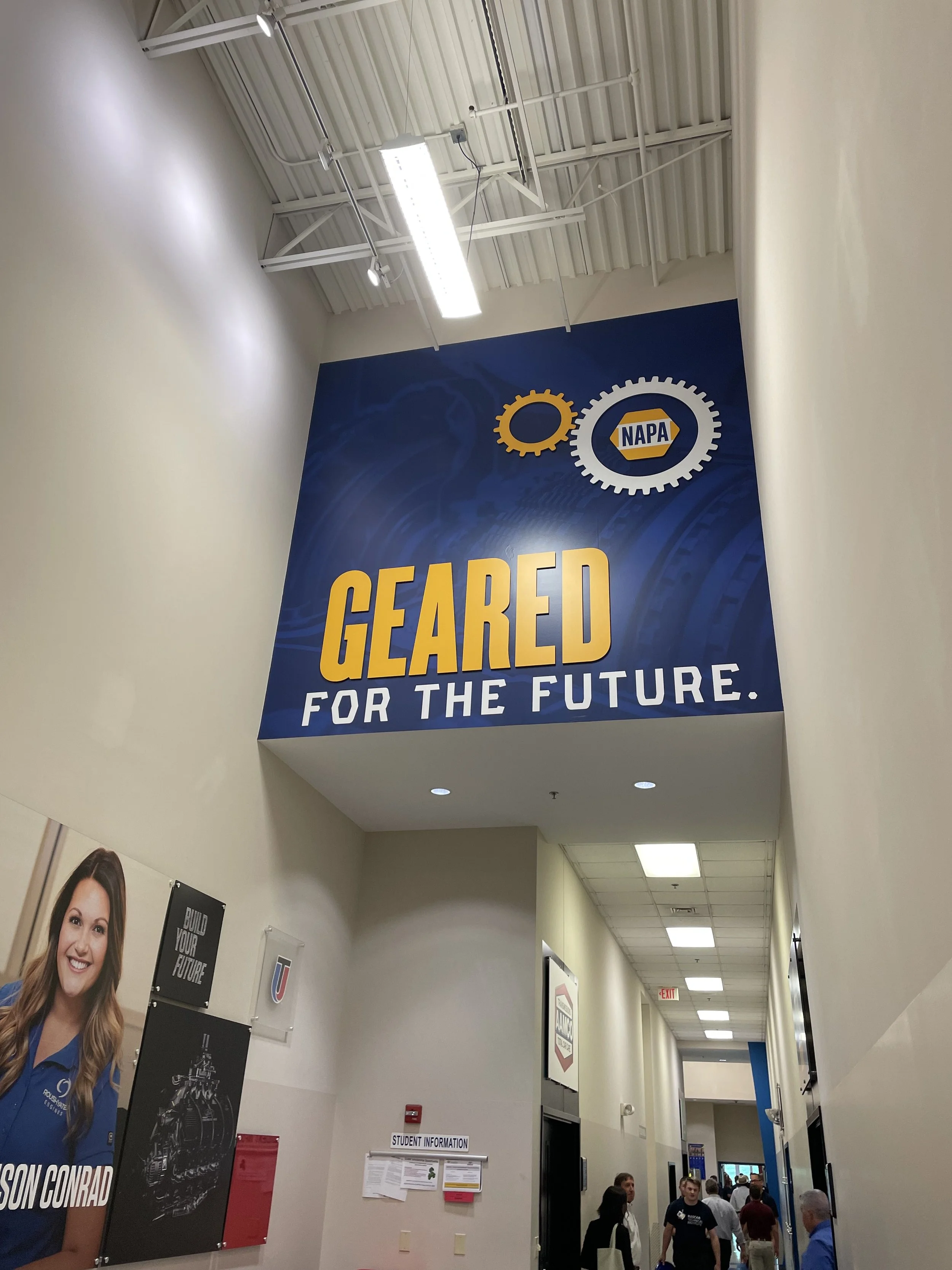 Large blue banner hanging in hallway with the NAPA logo and the text "GEARED FOR THE FUTURE."