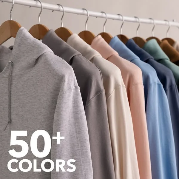 A row of hoodies hanging on a clothing rack in various colors including gray, dark gray, beige, pink, blue, and green, with the text "50+ Colors" in the lower left corner.