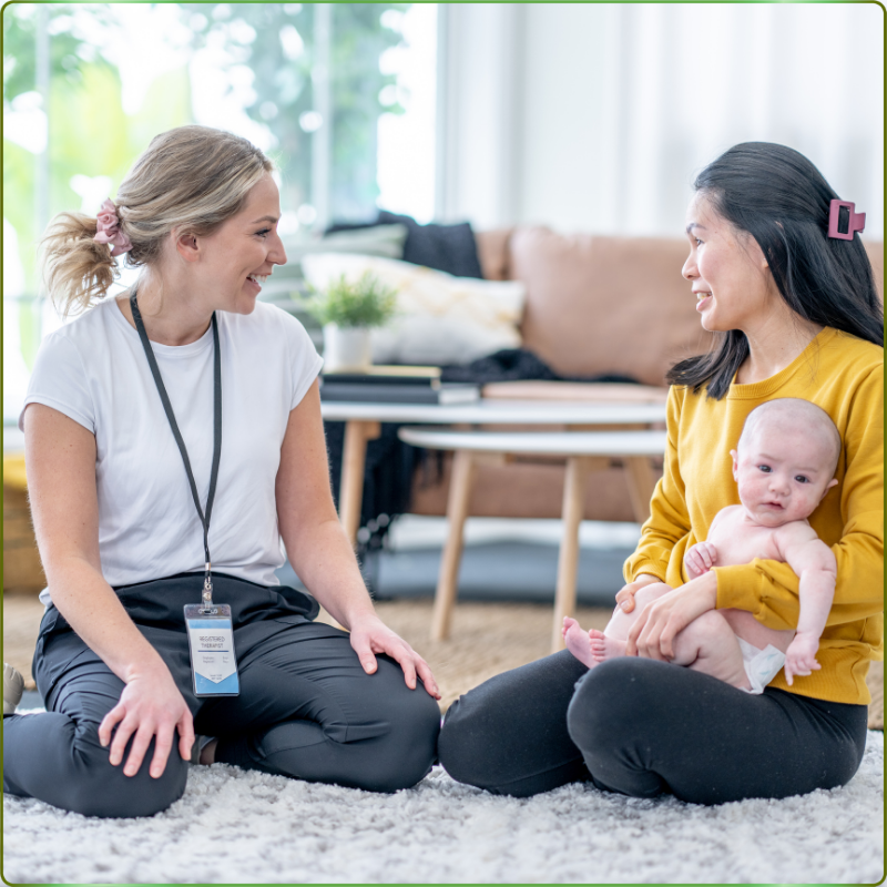 A postpartum doula in Cleveland helping a new mom with infant soothing and feeding support in a sunlit living room