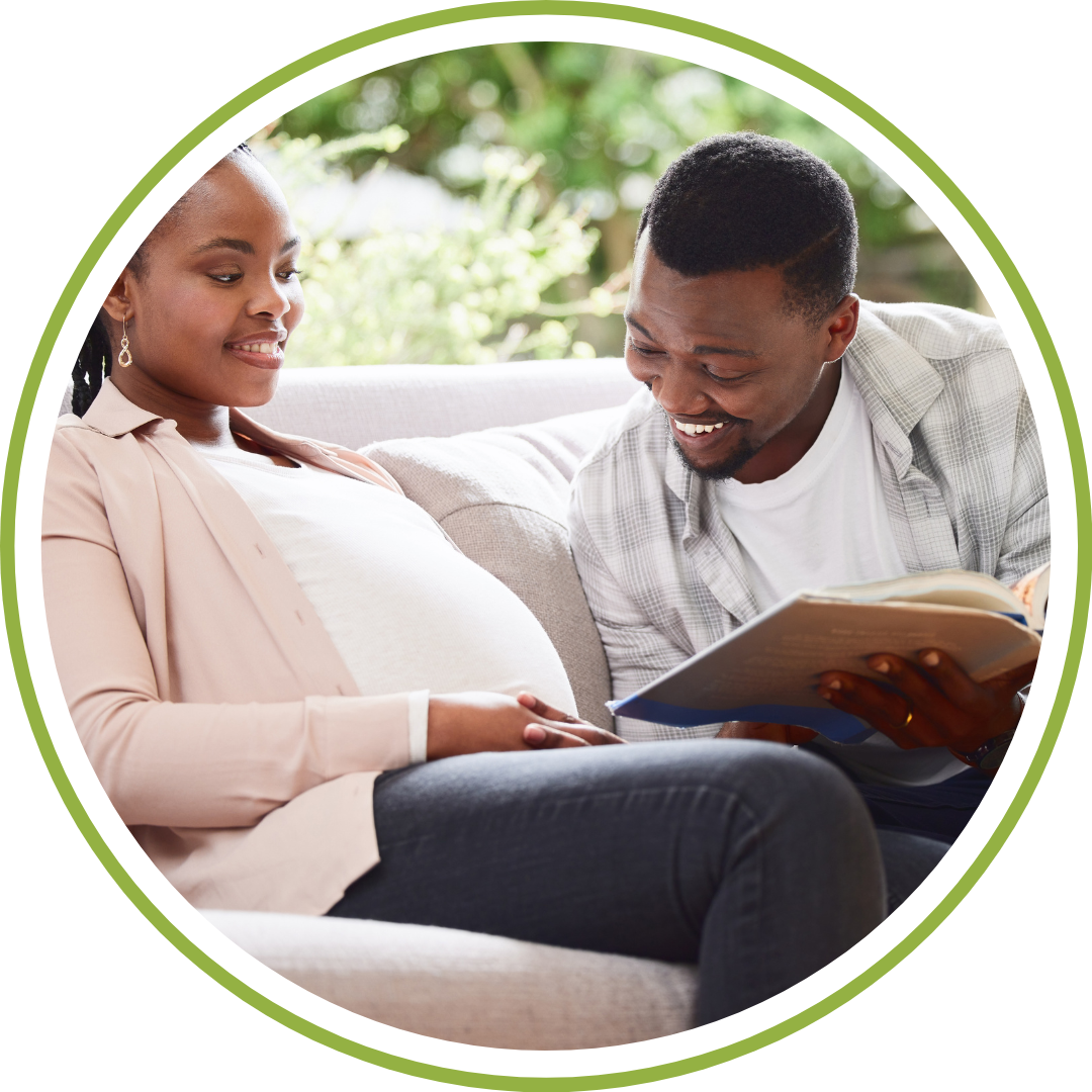 Expectant parents sitting comfortably on a couch with learning material during an independent birth preparation course