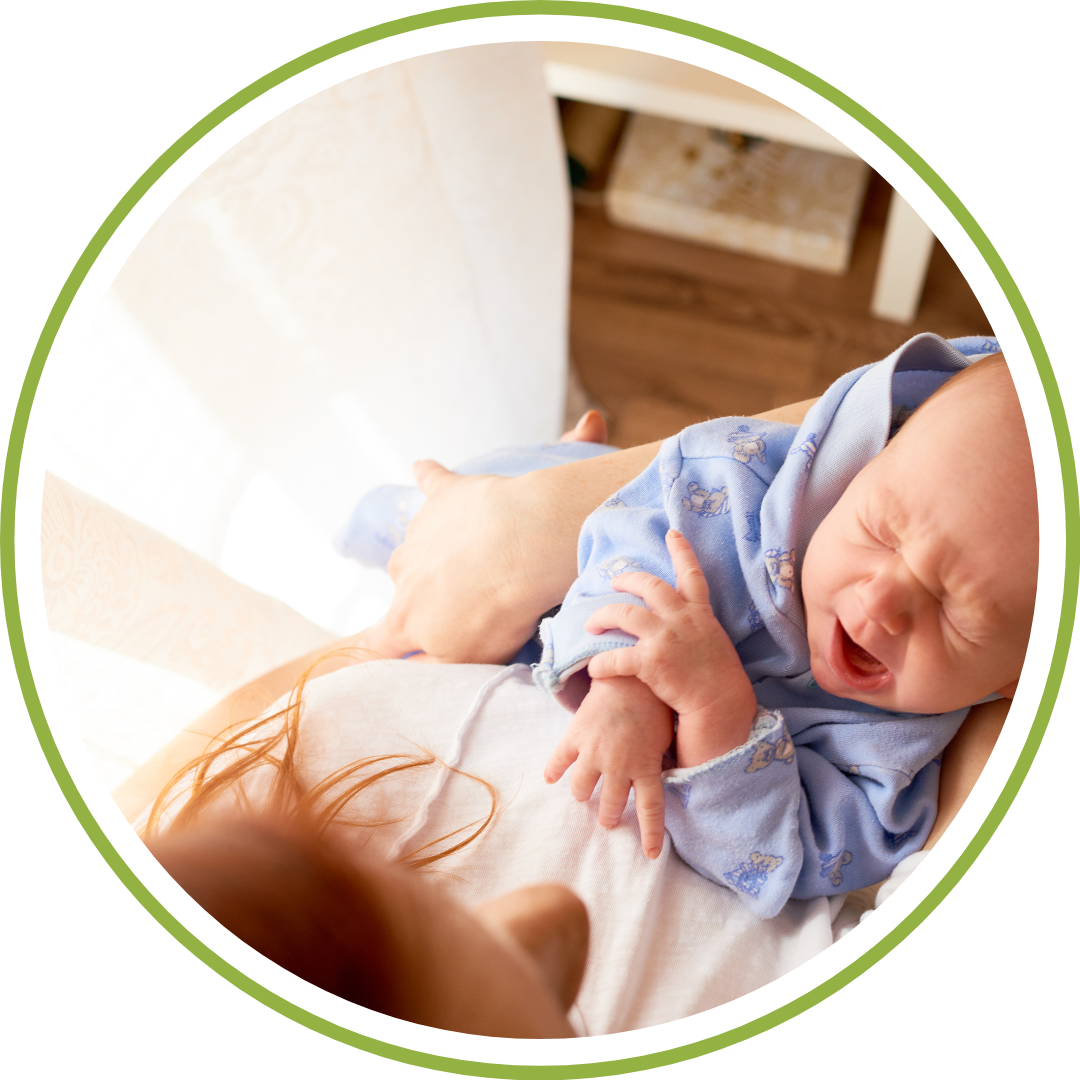 An overnight newborn care specialist gently soothing a baby in a dimly lit nursery while the parents rest.