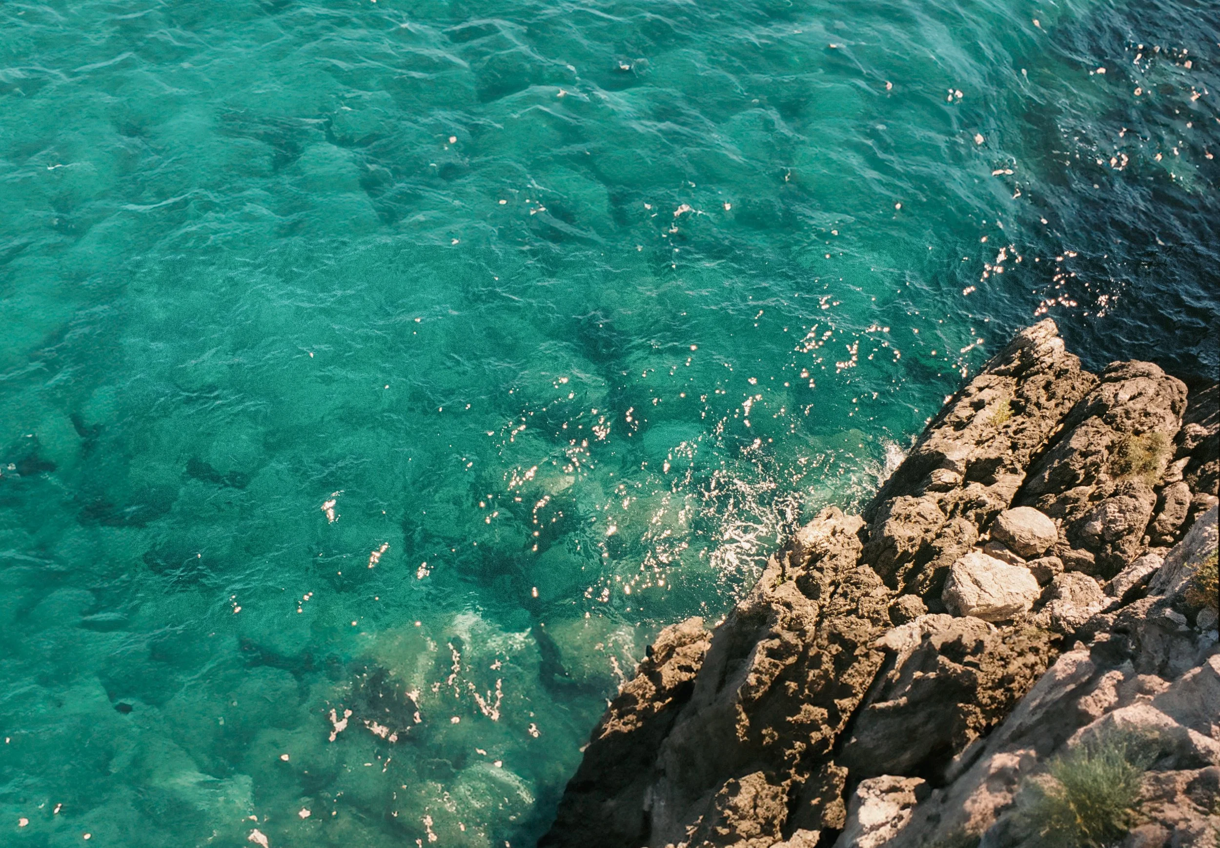 "Emerald Edge"
Waves lapping against sunlit rocks in transparent waters, Positano, Italy.