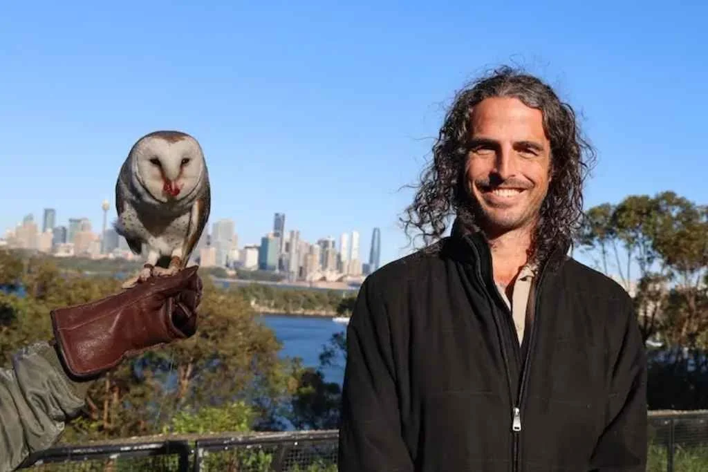 Alastair Duncan standing next to an owl