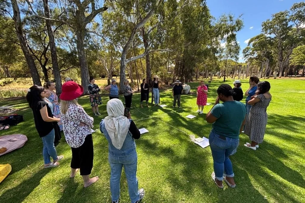 Circle of people standing out in nature during a workshop