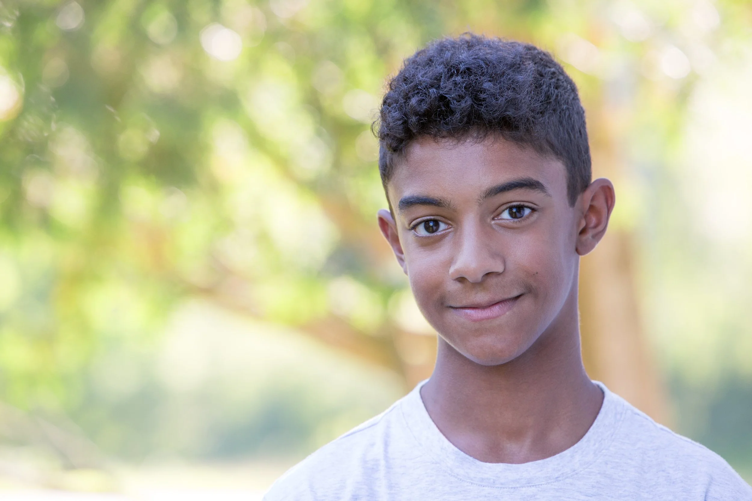 Elementary-aged boy smiling, representing diverse children engaged in a Christian Bible learning environment