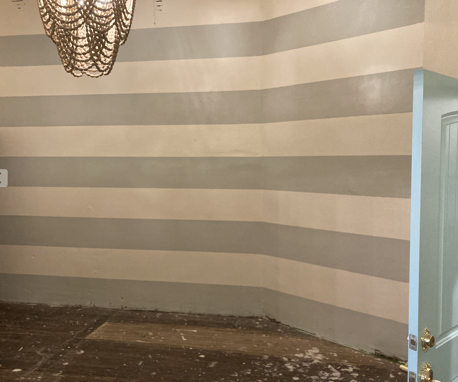A person painting a wall with a paintbrush.