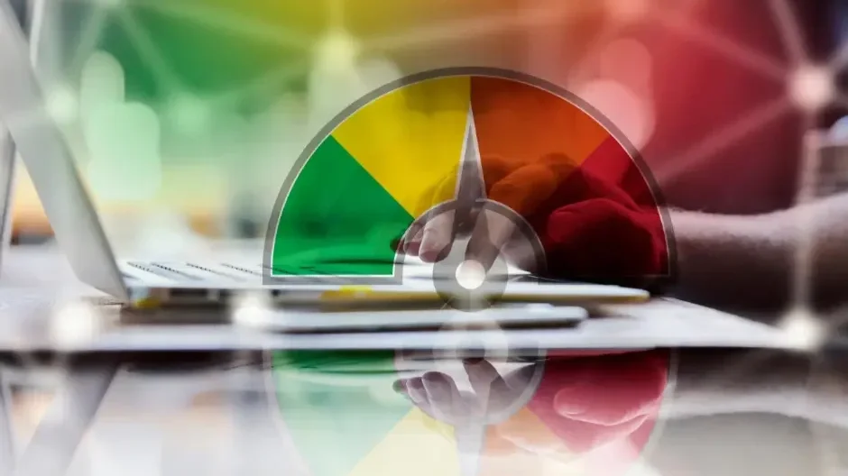 A person typing on a laptop with an overlaid semi-circular gauge indicating a high level in red.