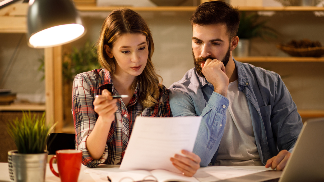 Couple looking over paperwork and thinking about proposal. Symbolising Mercer Funding Group supply our customers with financial package information regarding Private Lending options.