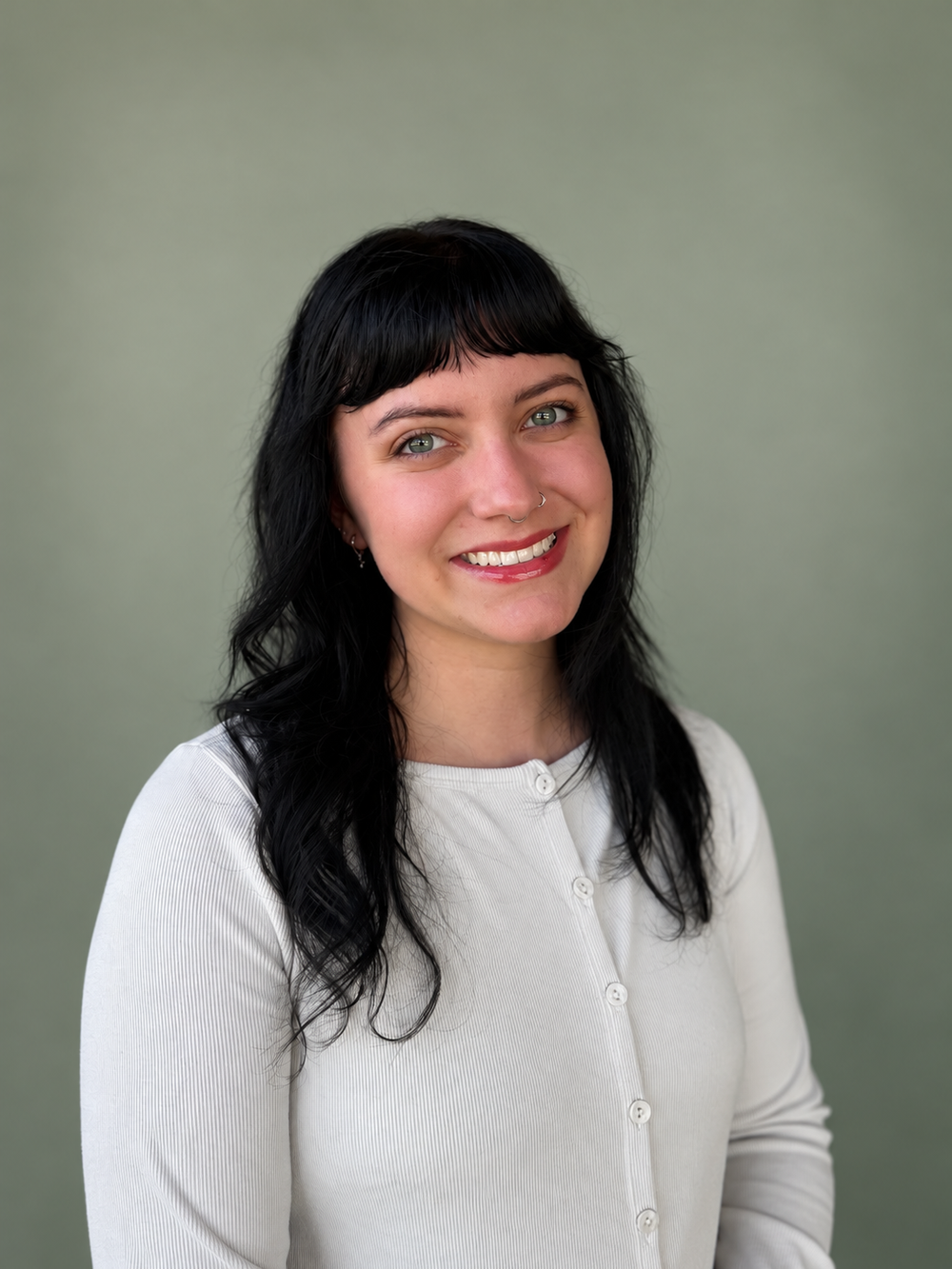 Madeline Brooks, LPC-Associate at Sentient Path, with dark wavy hair and a white blouse