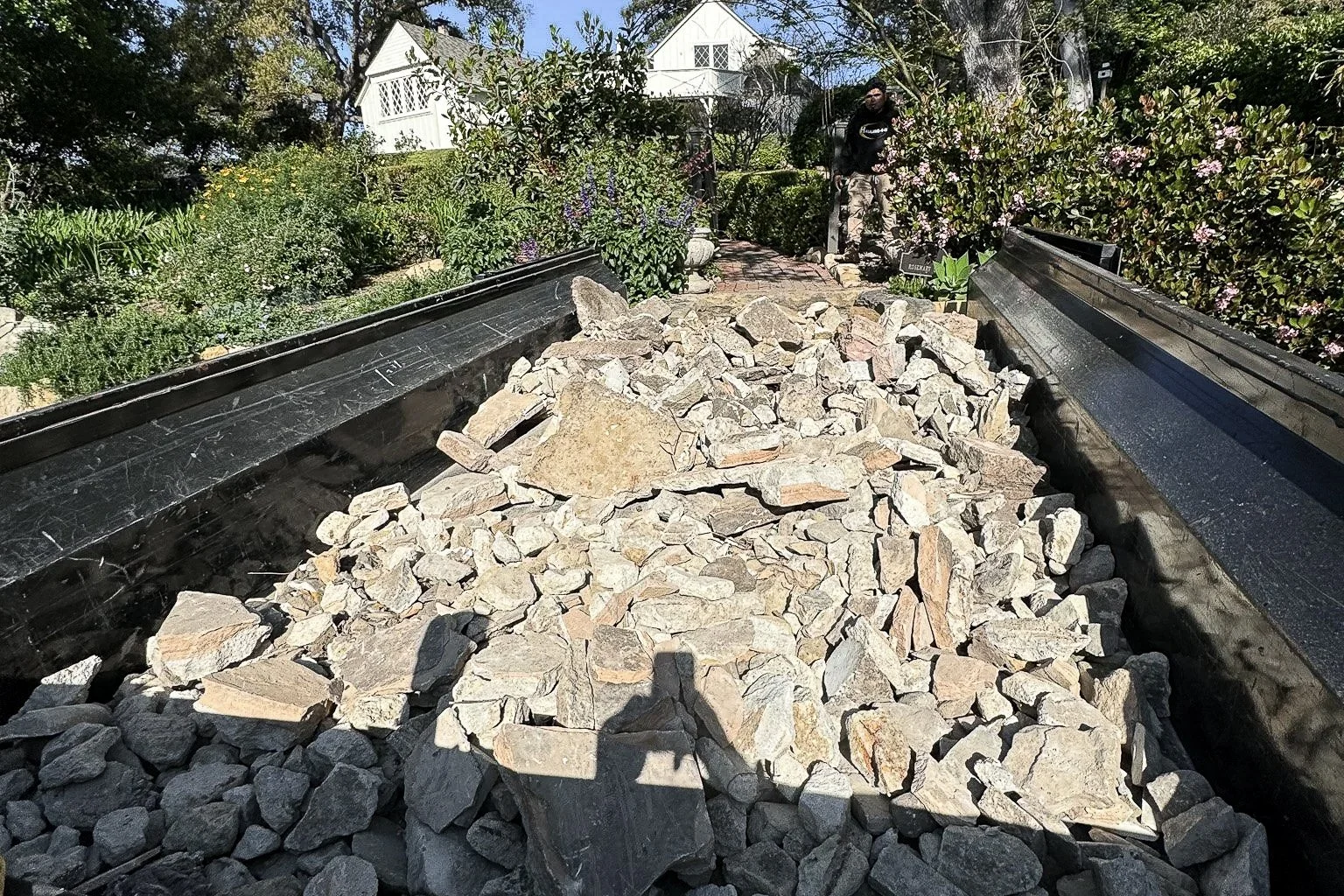 Hauling-4-U dump trailer loaded three quarters full with mixed rocks and stones for hauling.