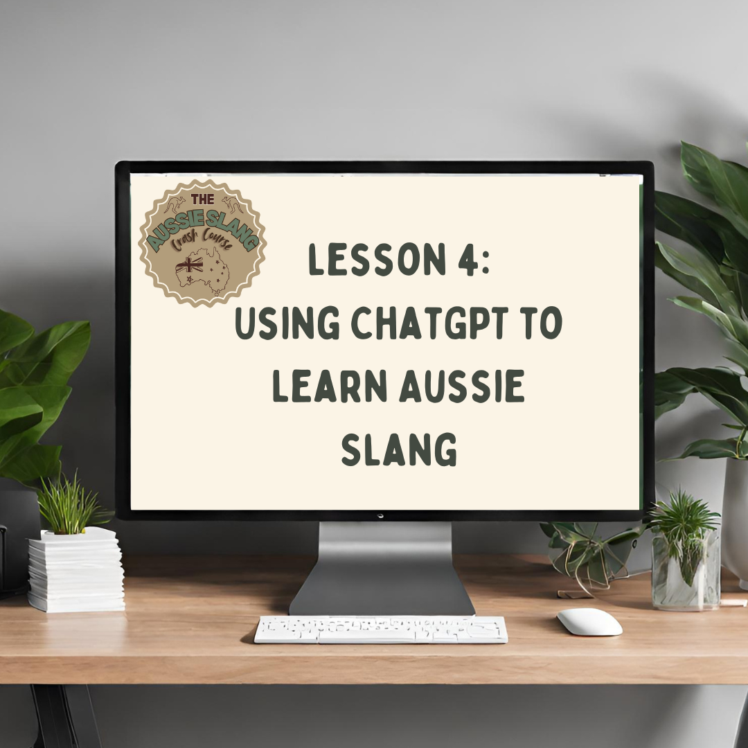 Computer monitor on a desk displaying text: 'Lesson 4: Using ChatGPT to learn Aussie slang' with a logo in the top left corner. Surrounding elements include plants, a keyboard, and a mouse.