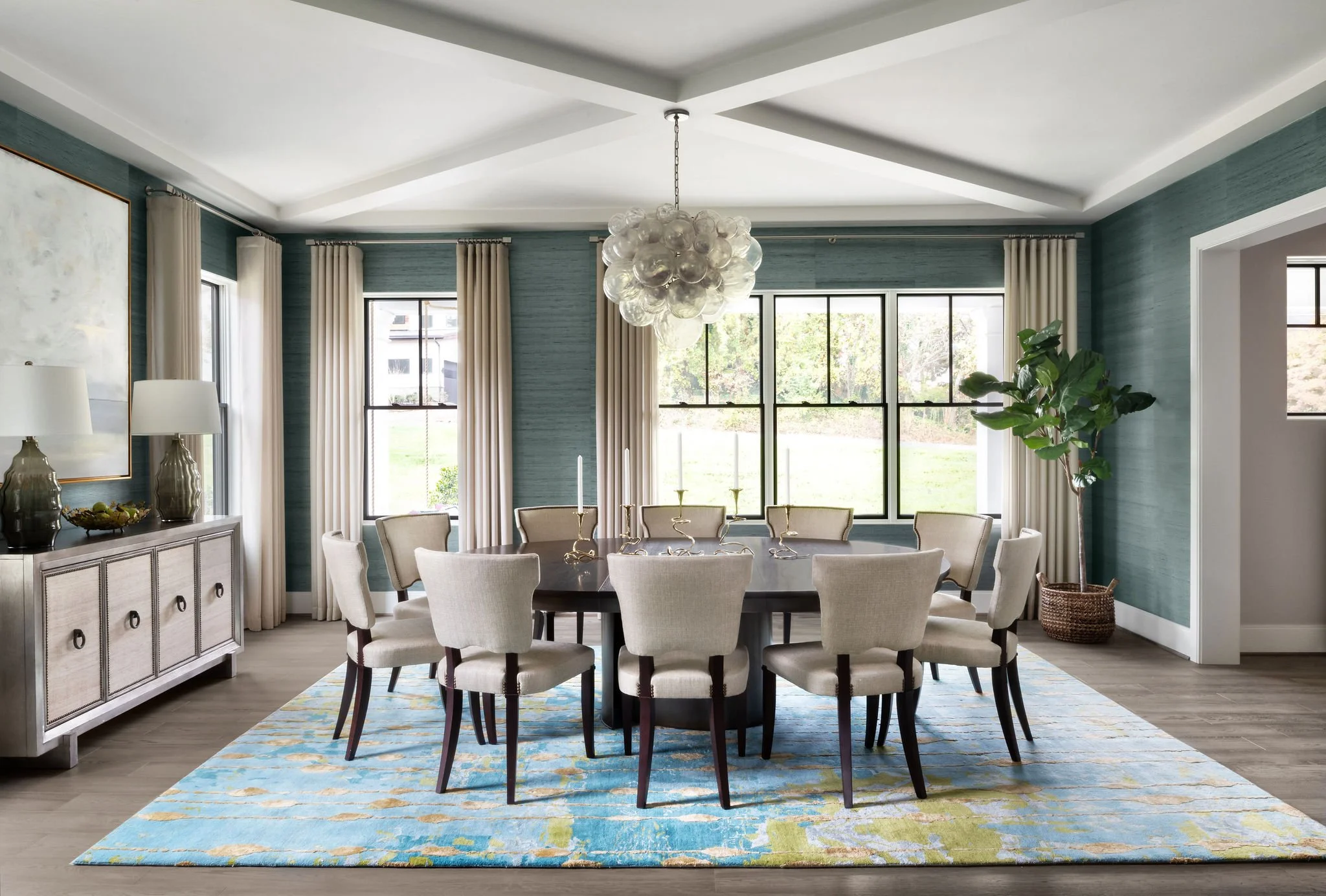 Luxury dining room featuring an Oly Studio focal point light fixture and curated furniture to create a centered gathering space.