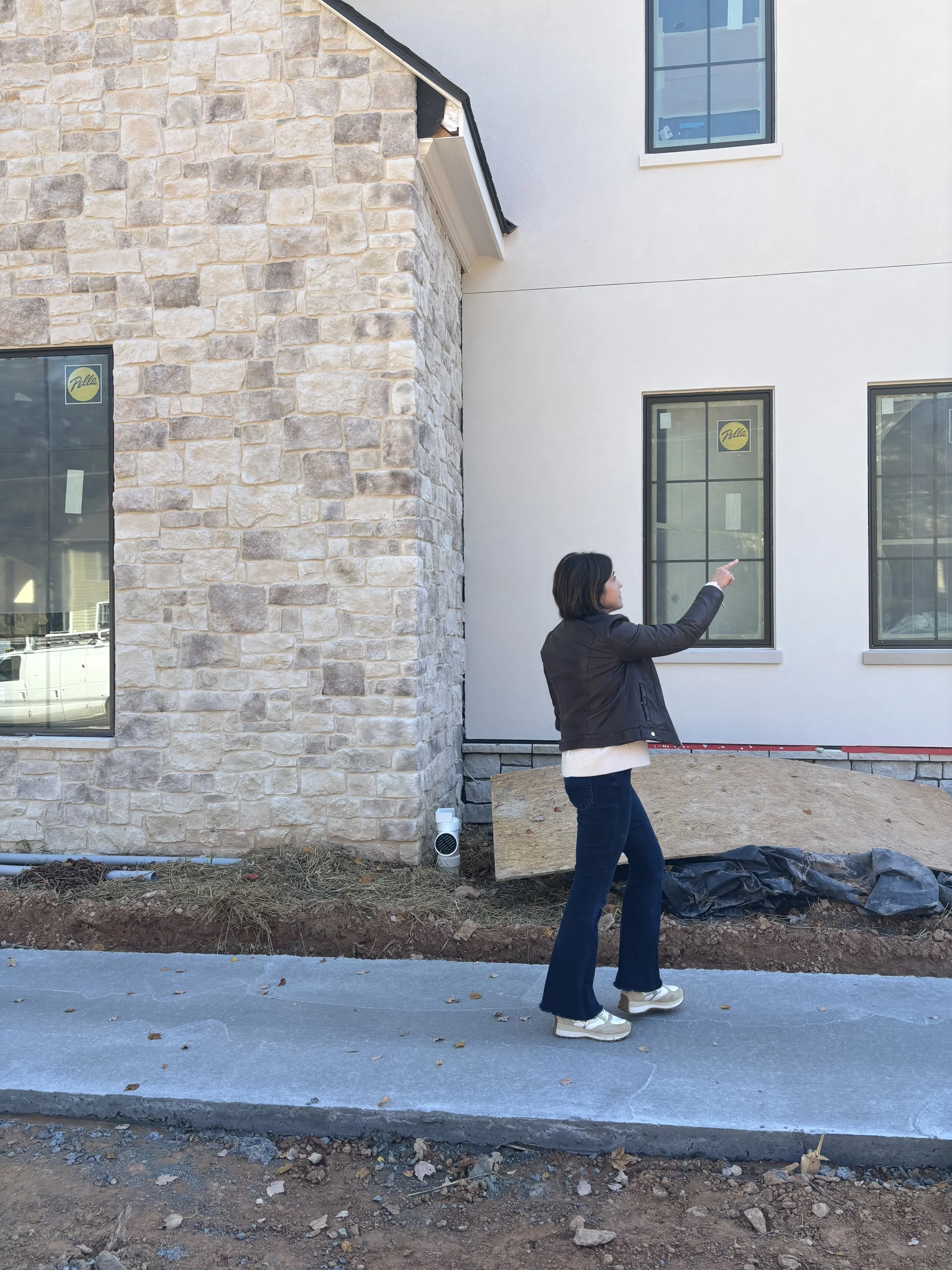 Interior designer Andrea Maaseide reviewing exterior window border colors at a Vienna construction site.