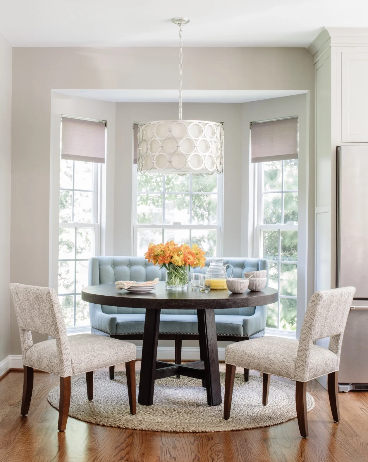Luxury breakfast nook in a Northern Virginia home featuring a soft teal Vanguard Furniture bench aligned with a large window for perfect balance.