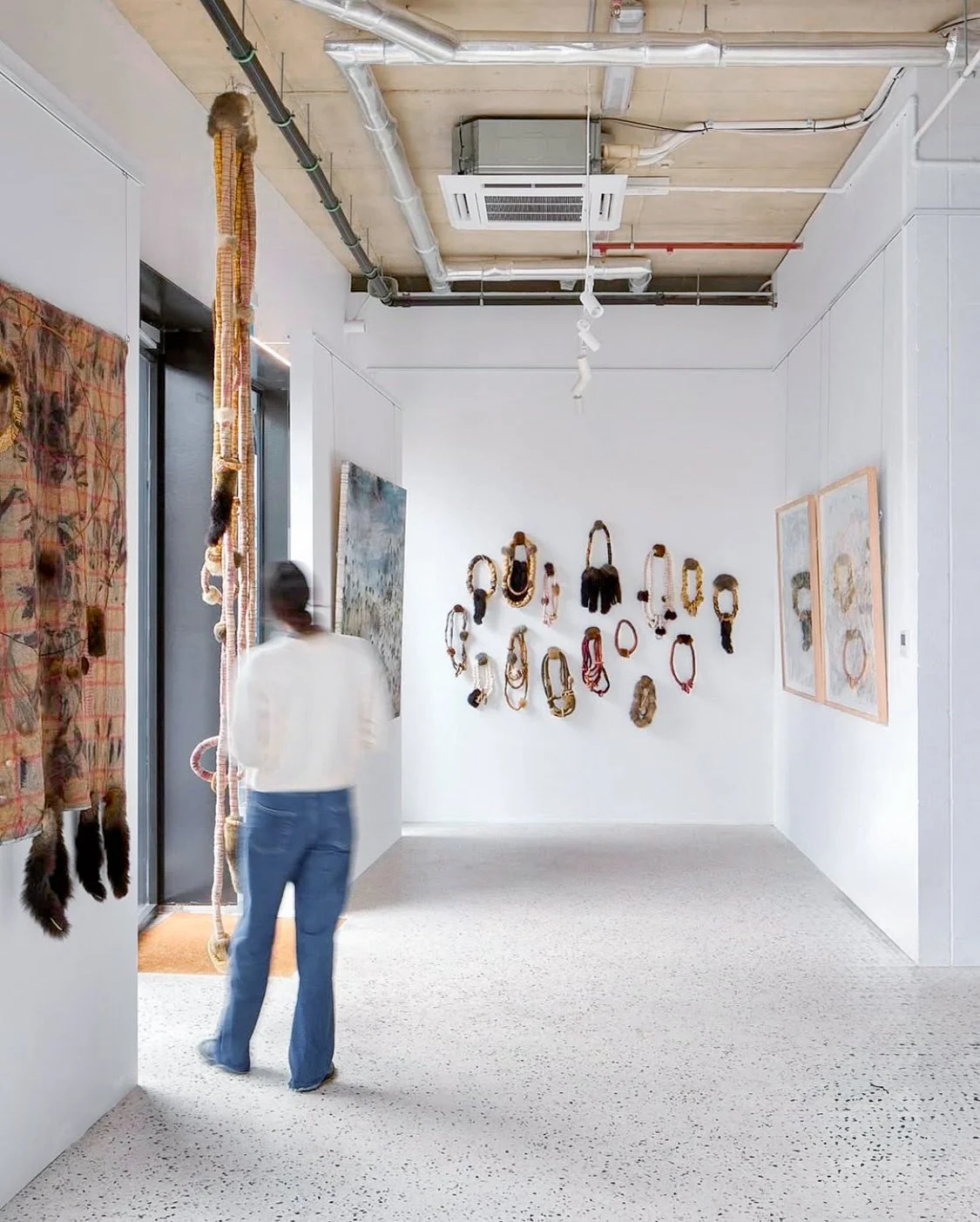 Cultural institution installation of contemporary portraits and suspended textiles by Melbourne Art Services.