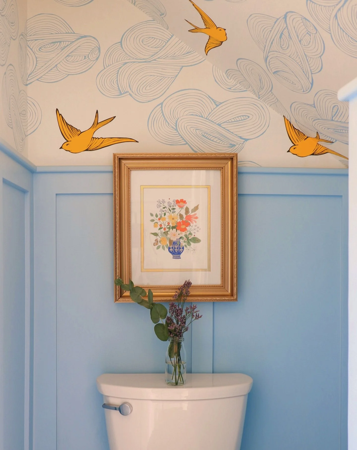 More work than it looks. Exactly as it should be.
Soft blue paneling grounding the room, with wallpaper doing the rest&mdash;clouds and birds opening it up, letting it feel larger than it is.

#JessieSurberInteriors
#ArtfullyLayered
#DesignWithDepth
