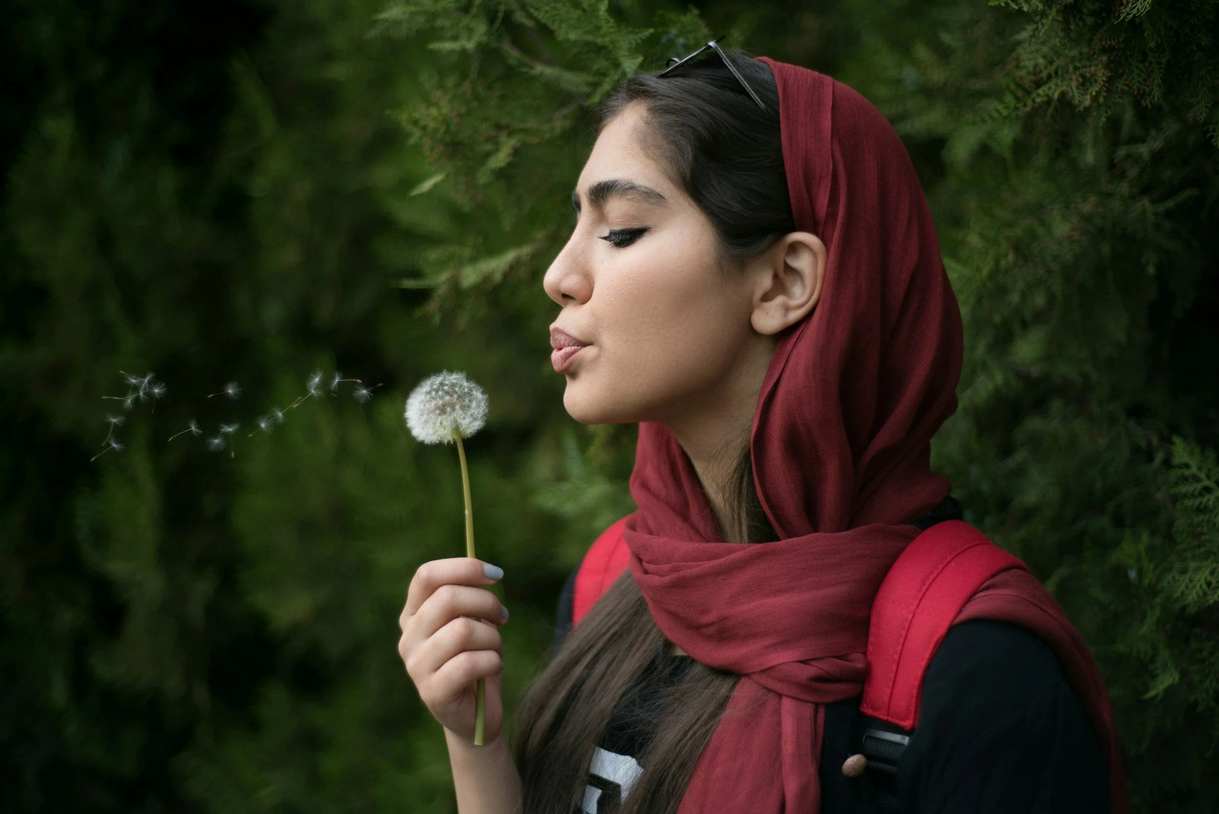 woman blowing a dandelion, representing how MEMI processes painful memories quickly, gently and permanently